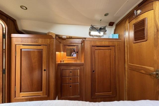 Wooden interior of a 2002 Saga 43 boat, featuring cabinets and drawers.