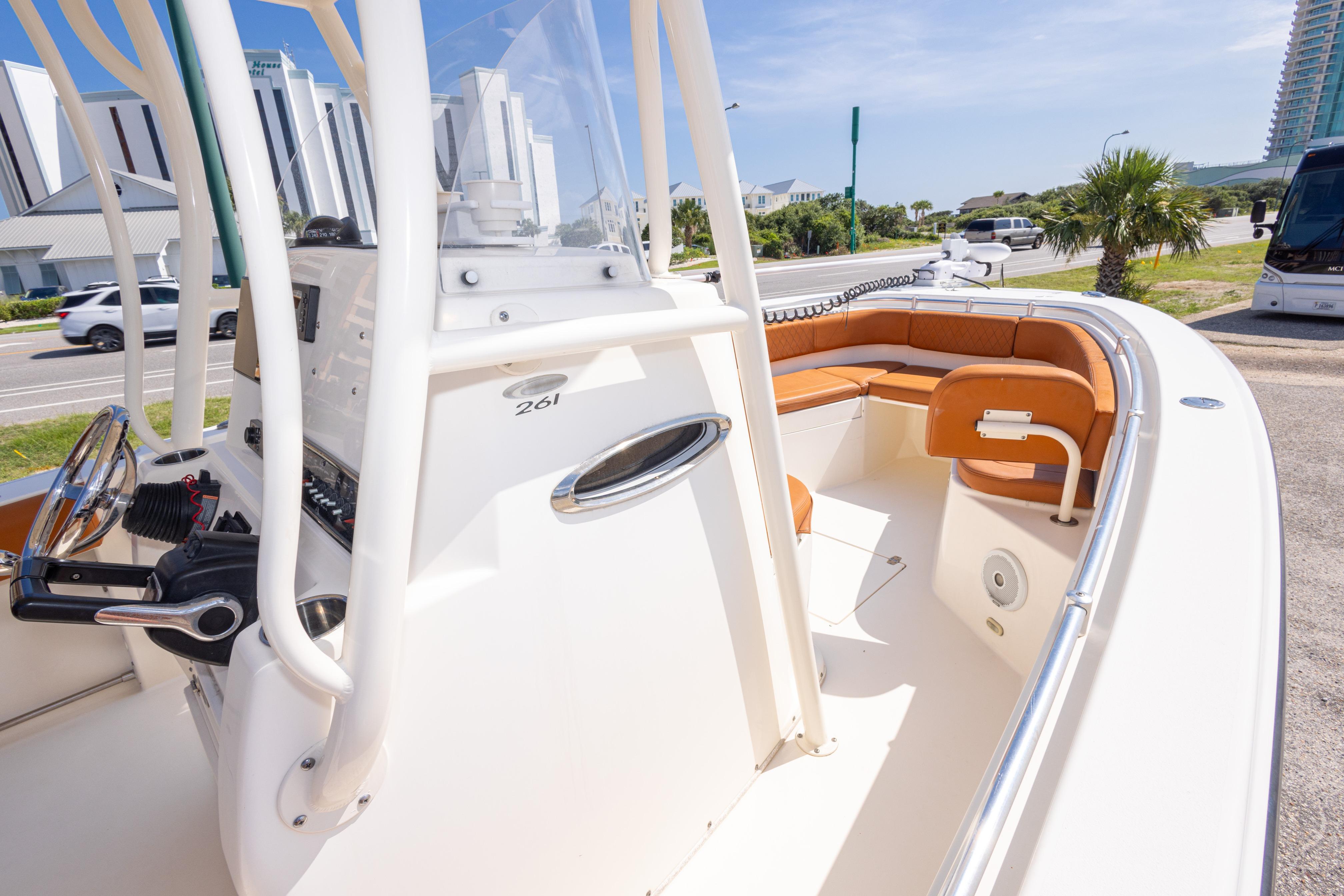 2017 Cobia 261 Center Console boat with tan seating, parked near a road.
