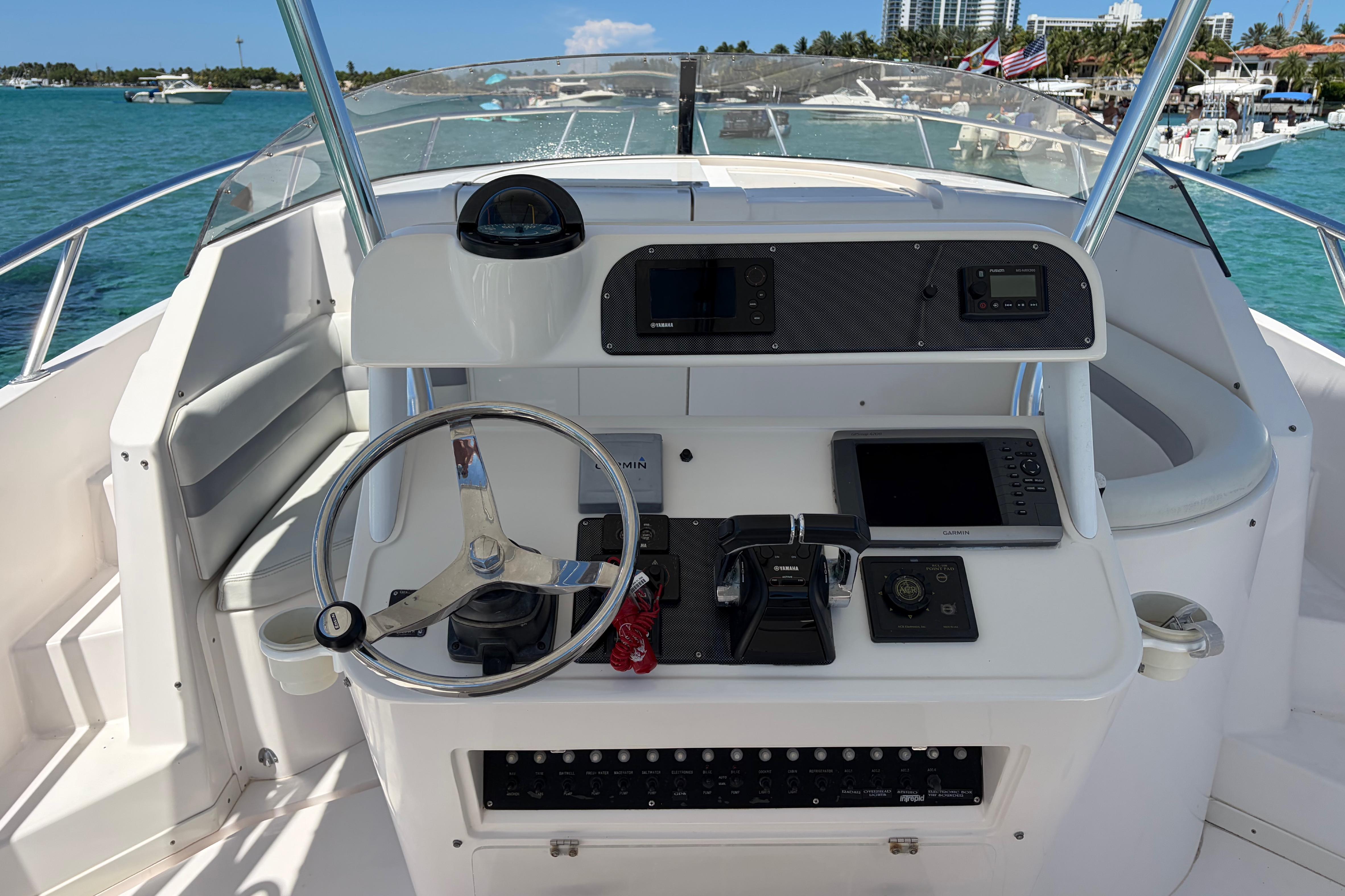 1998 Intrepid 339 Walkaround boat helm with steering wheel and navigation equipment.