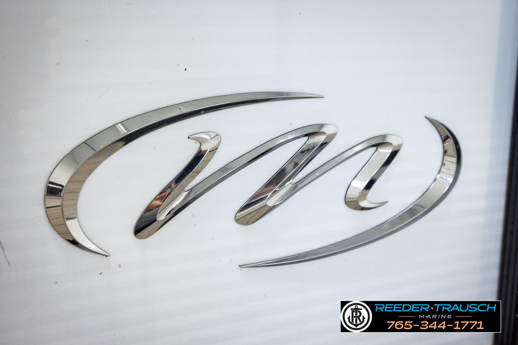 Chrome logo of 2019 Manitou Oasis SR VP boat, featuring sleek design elements.