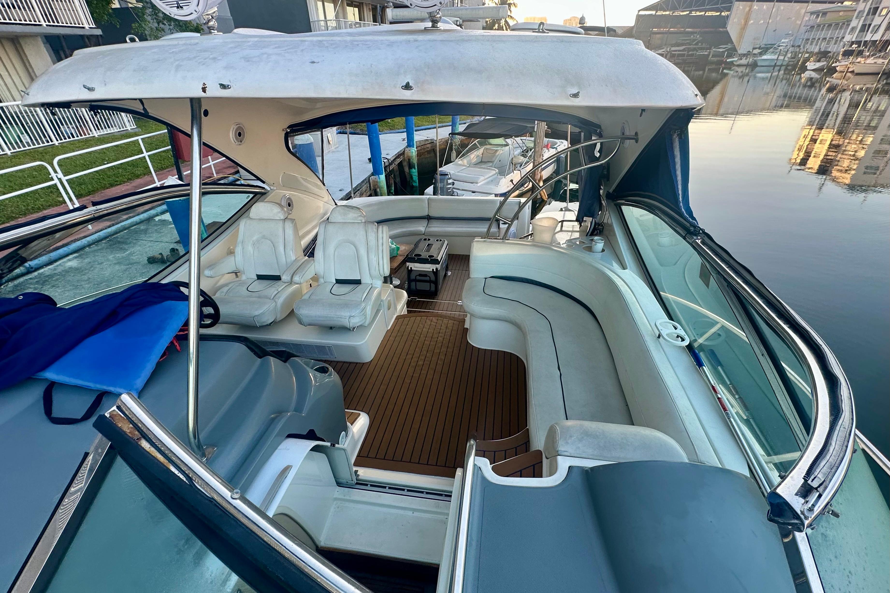 2005 Cruisers Yachts 500 Express interior with seating and helm, docked by the water.