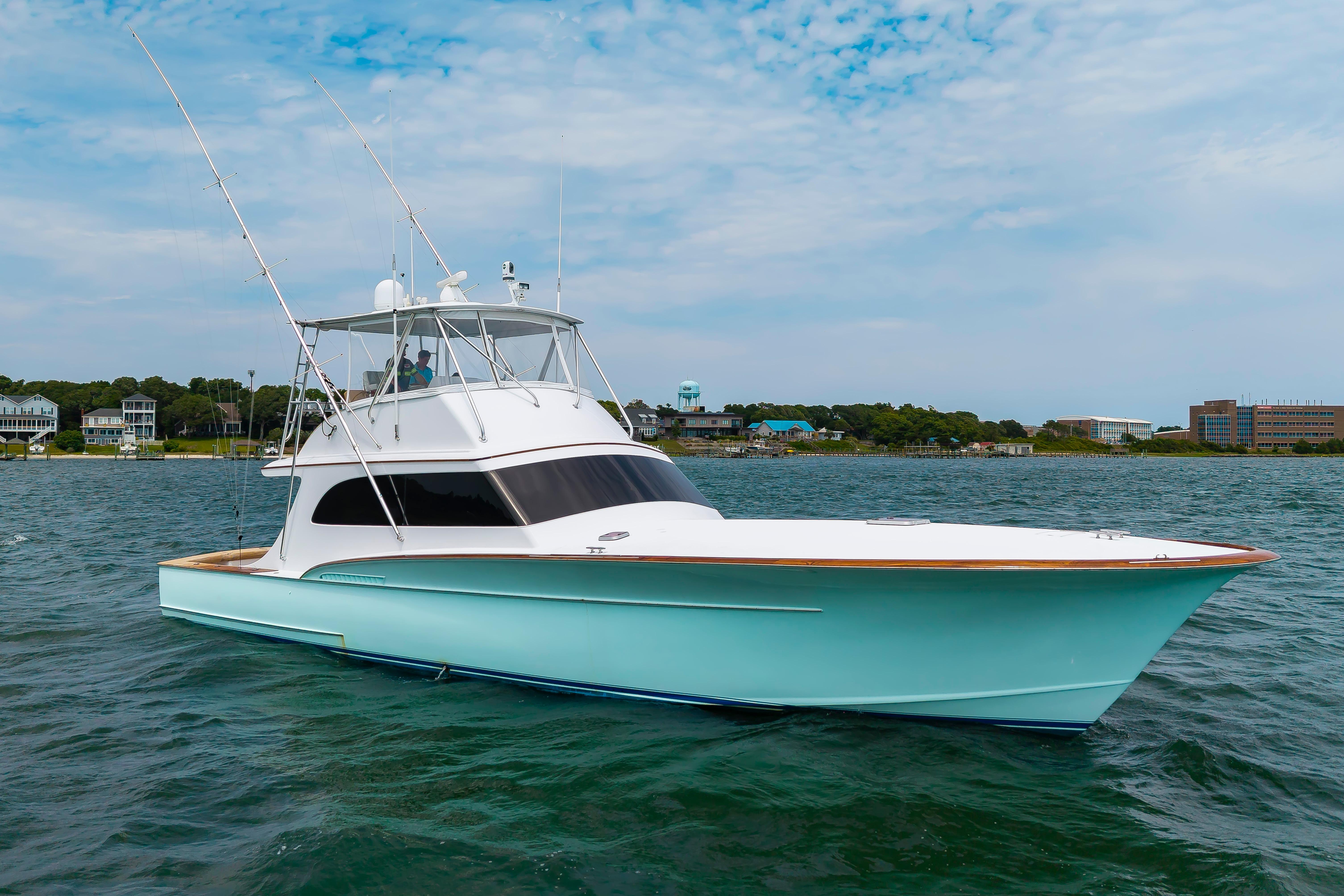 1993 Custom Carolina Scarborough 56 Convertible yacht on calm water, with coastal buildings in the background.