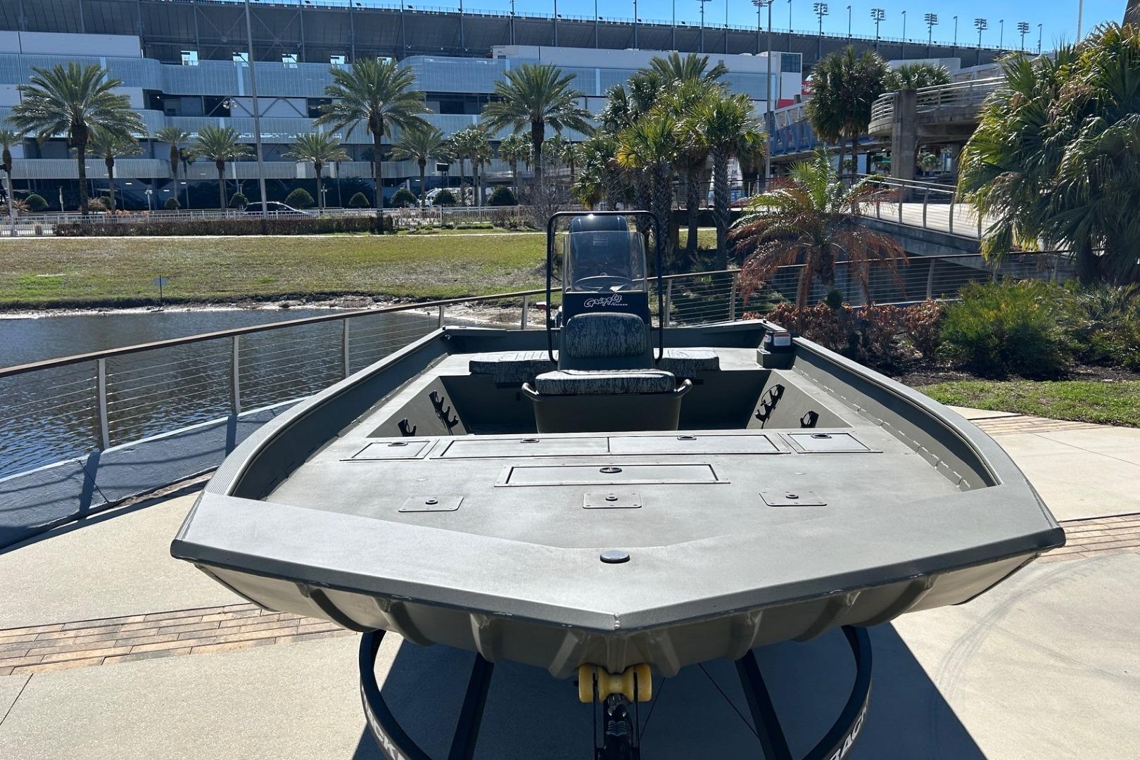 2026 Tracker Grizzly 2072 CC boat displayed outdoors near water and palm trees.