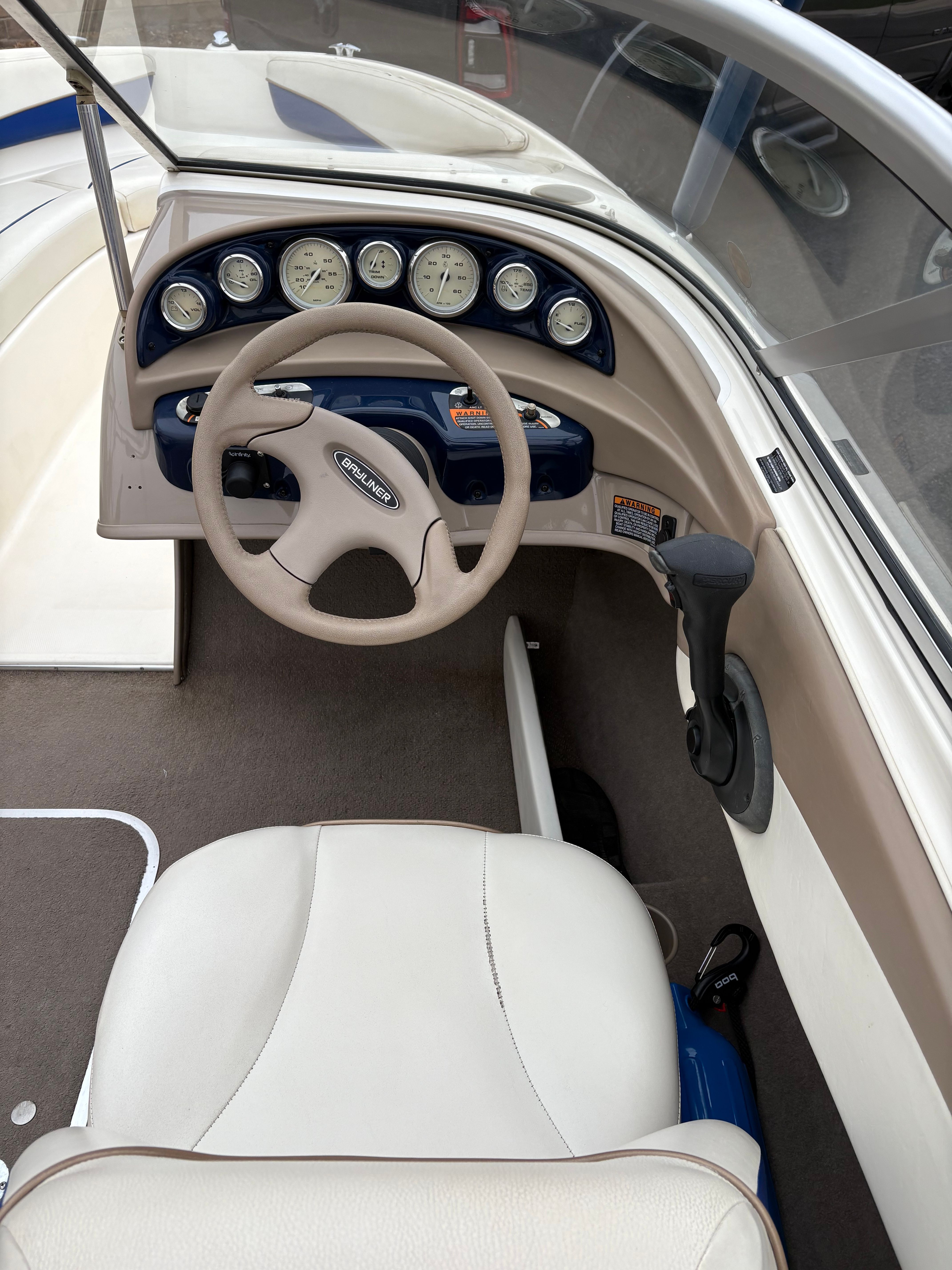 2003 Bayliner CAPRI 205 boat cockpit with steering wheel and instrument panel.