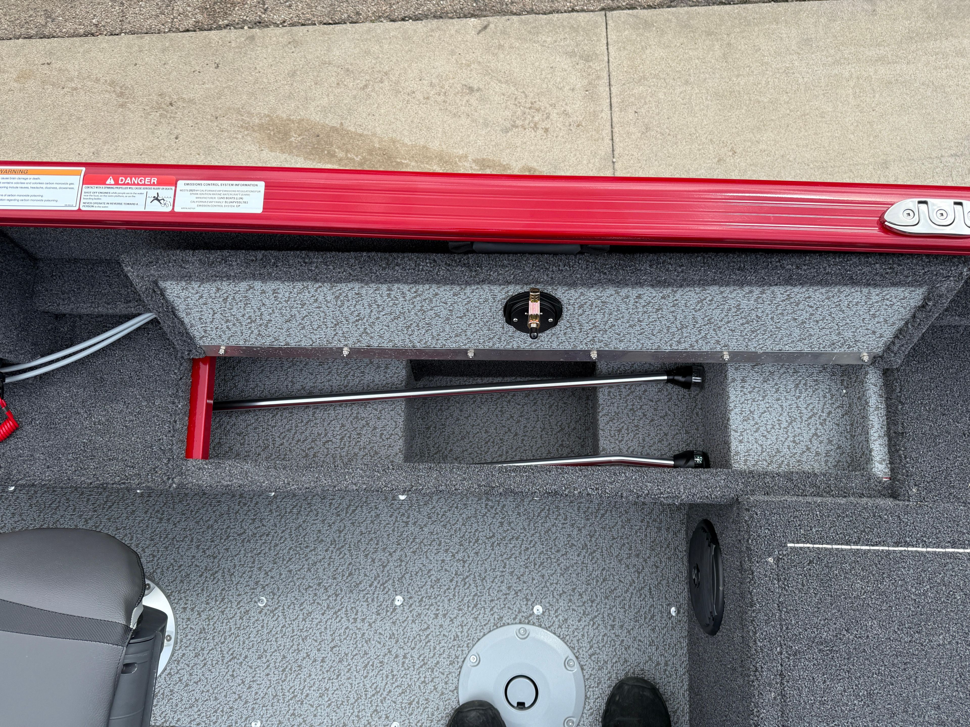 2025 Lund 1650 Rebel XL SS boat interior with storage compartment and red trim.