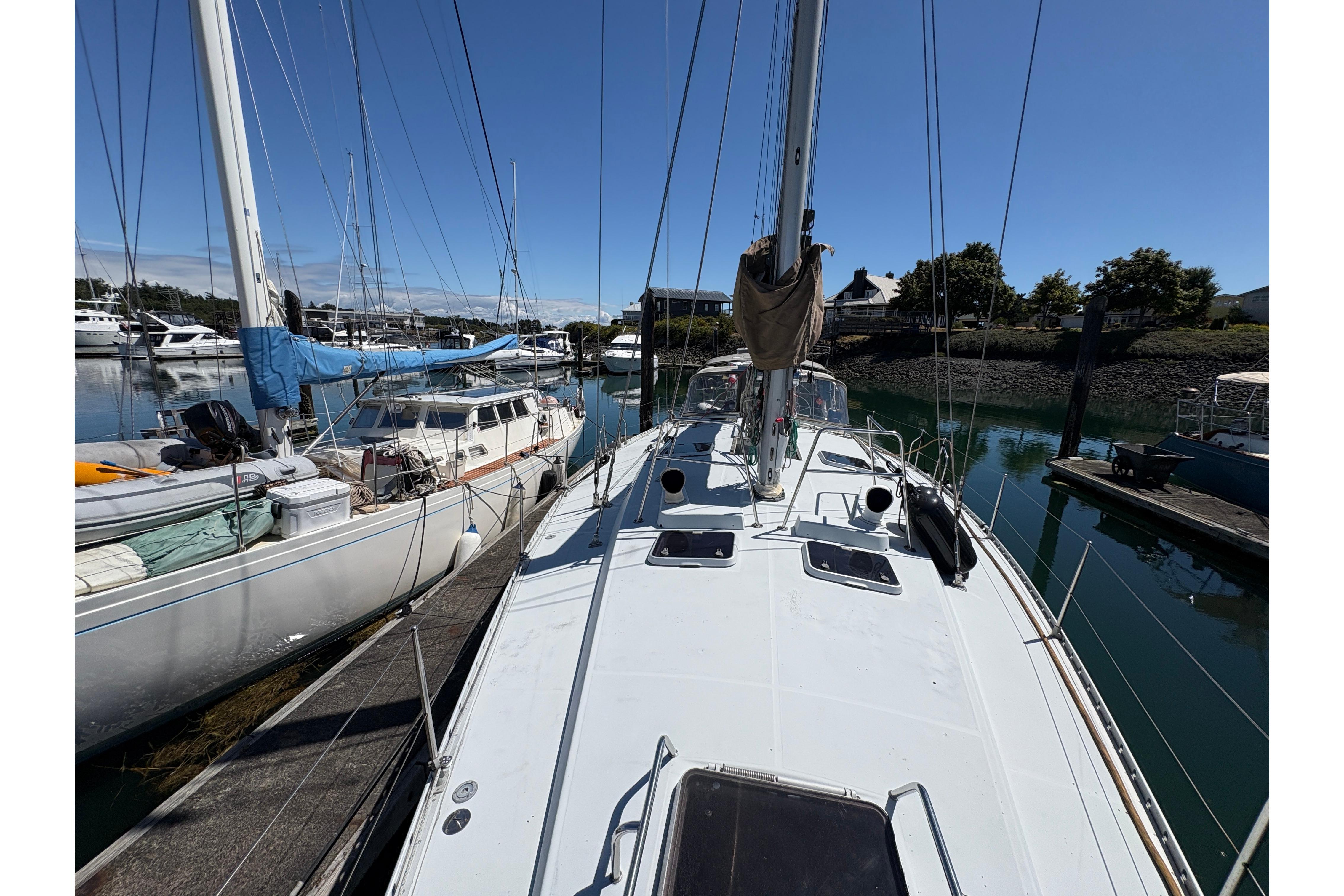 1990 Beneteau Oceanis 500 sailboat docked in a marina under clear blue skies.