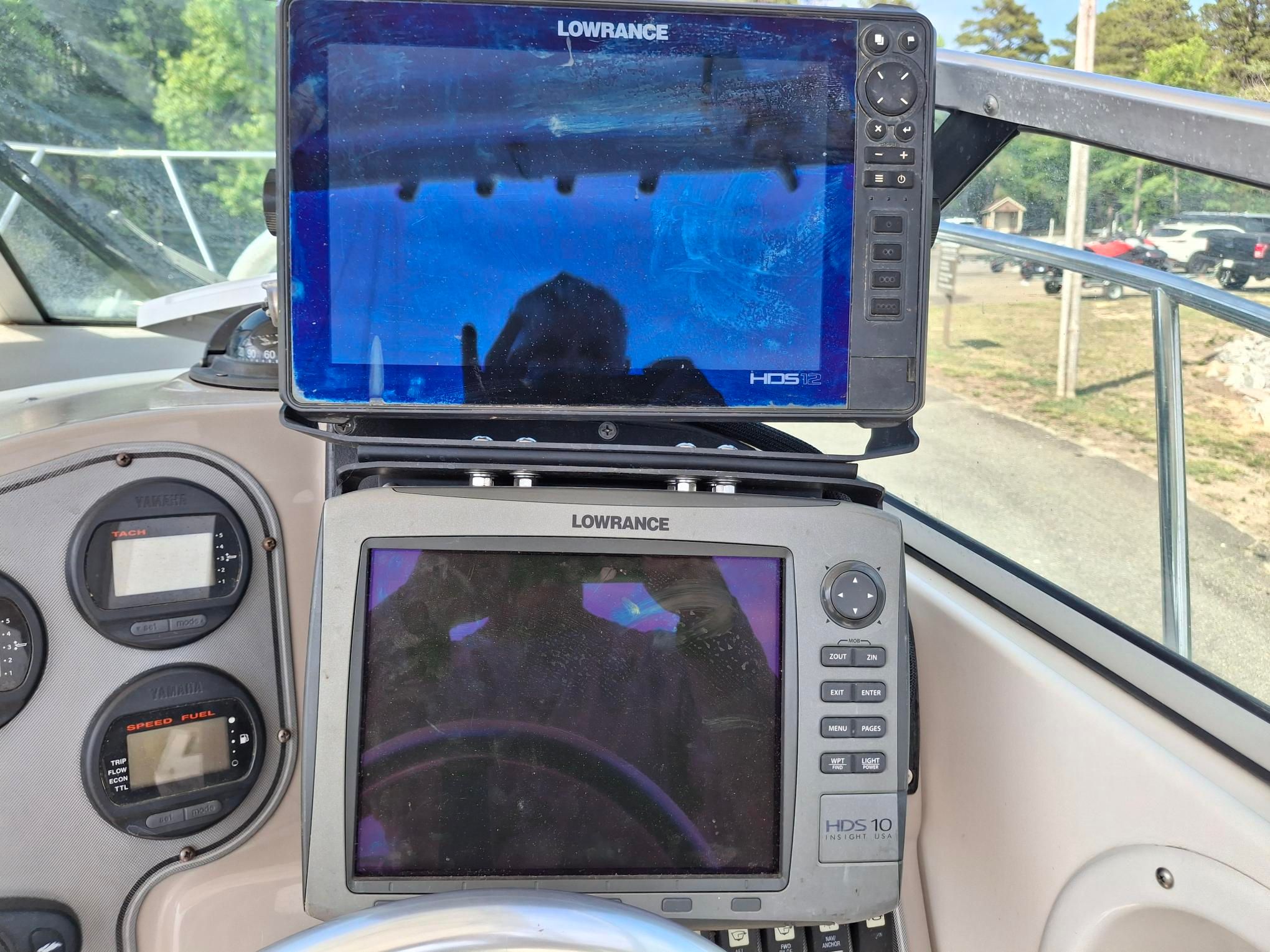 The image shows two Lowrance screens on a boat, surrounded by instruments.