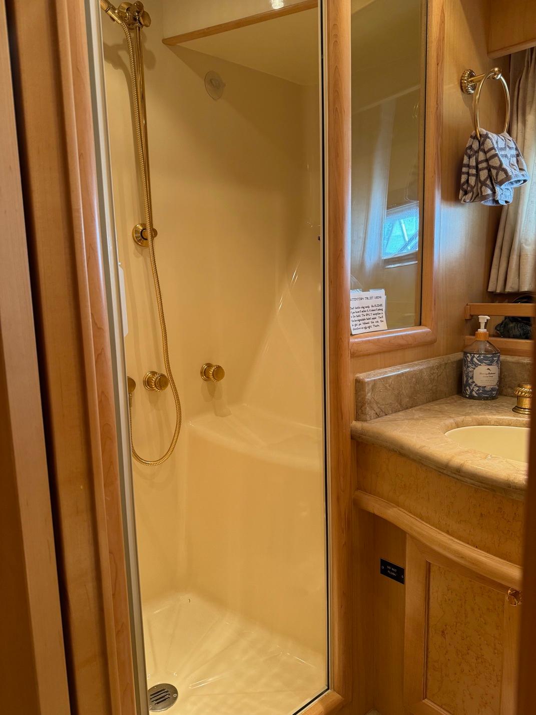 Luxurious bathroom in 2000 McKinna 57 Pilothouse yacht with shower and vanity.