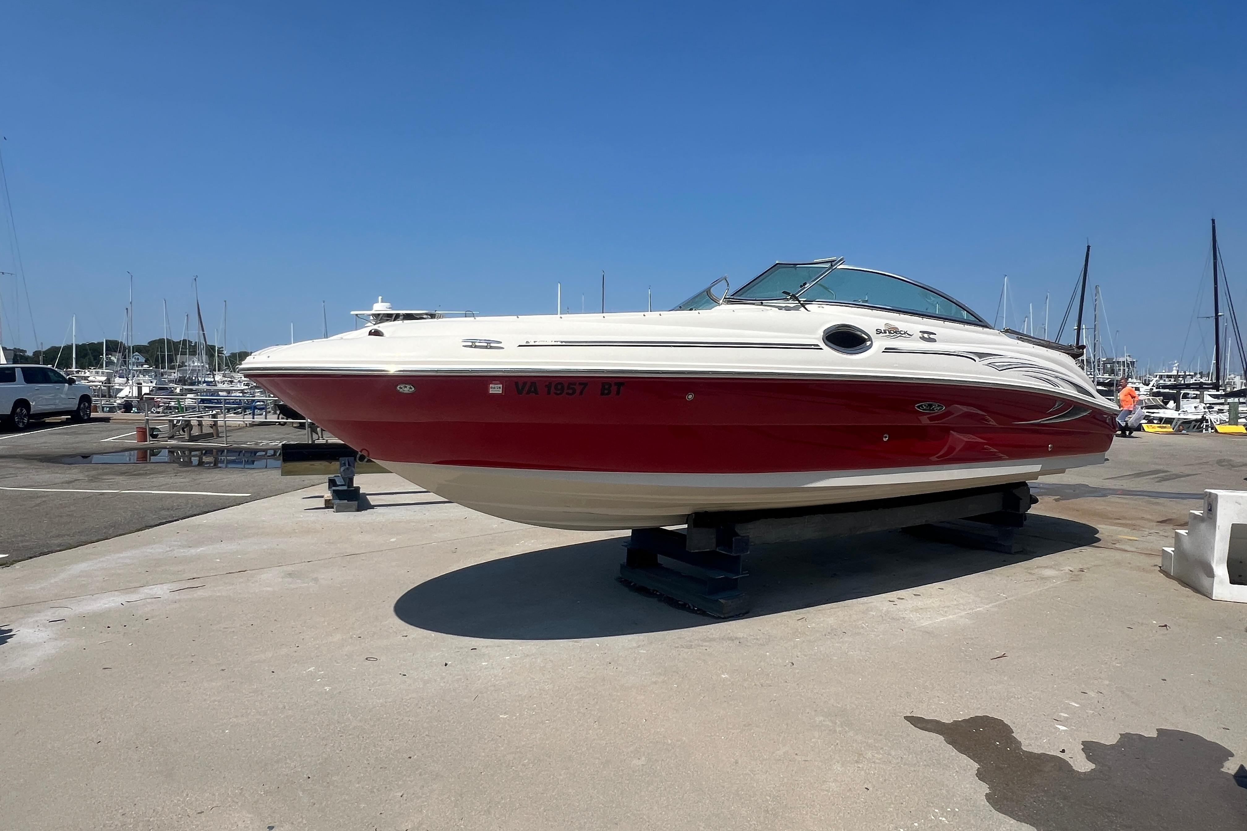 2005 Sea Ray 240 Sundeck boat on dry dock at marina, clear blue sky.