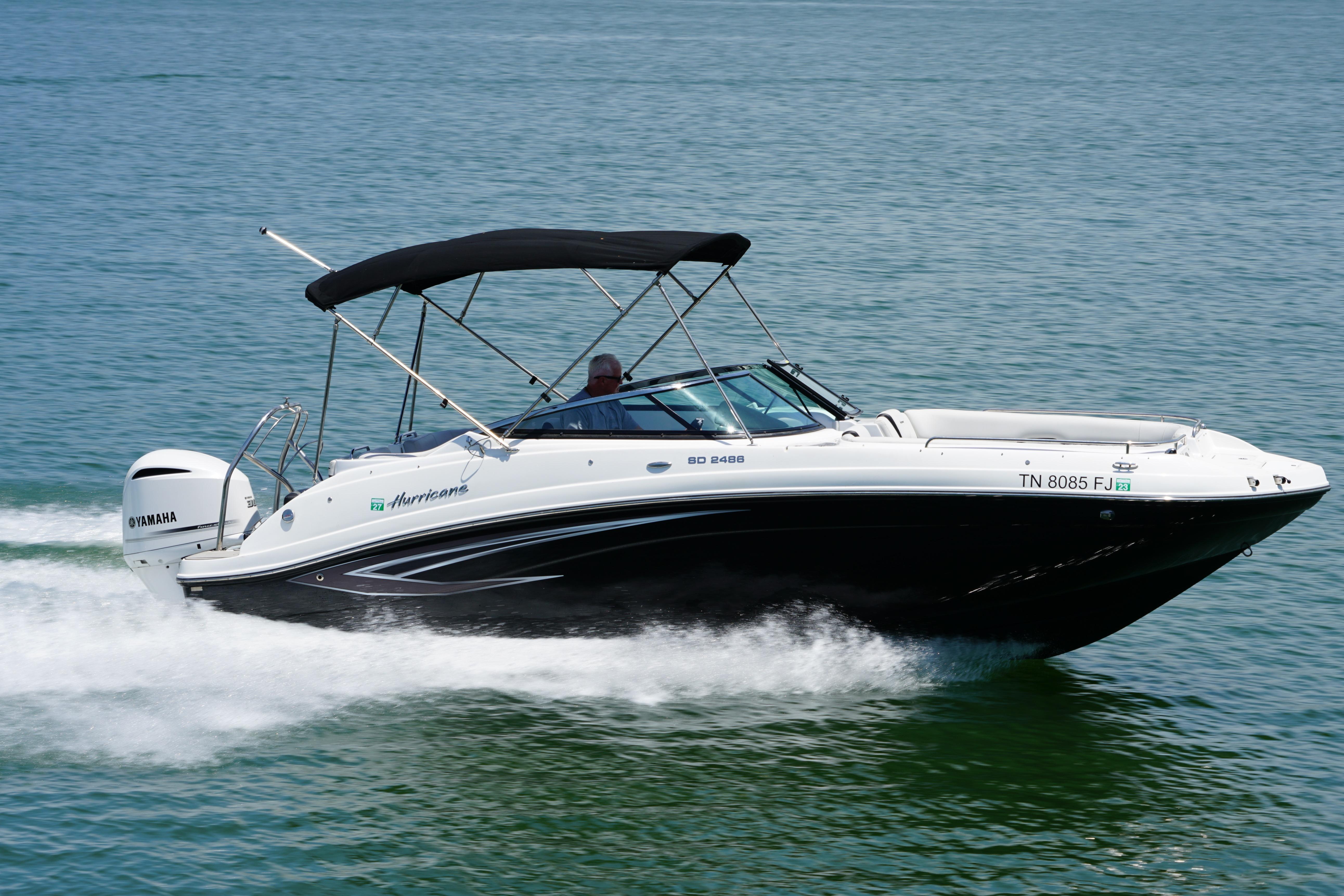 2020 Hurricane SunDeck 2486 OB boat cruising on water with Yamaha engine.