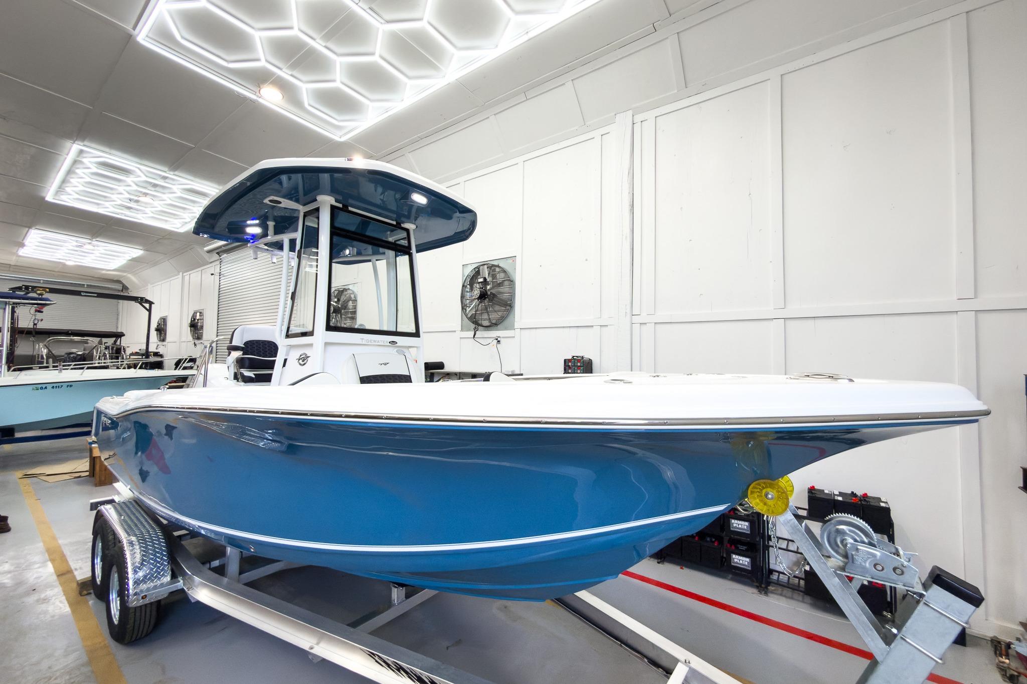 A blue Tidewater 220 LXF boat from 2026 sits on a trailer in a warehouse.