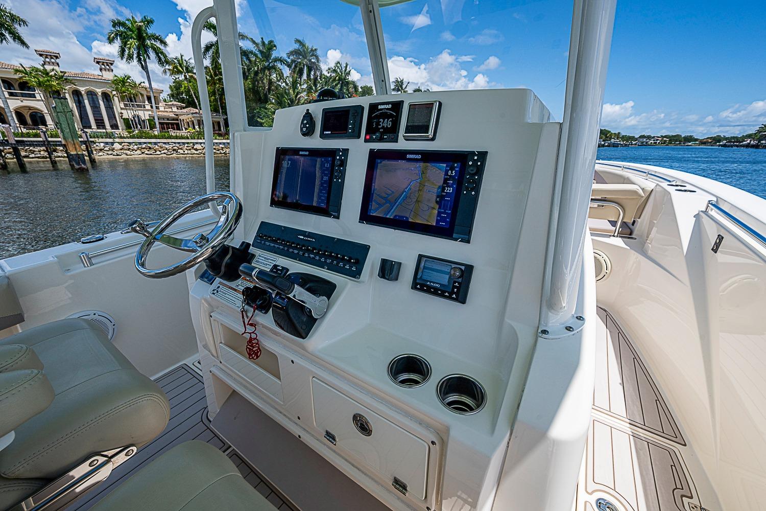 2019 Cobia 320 Center Console boat dashboard with navigation screens and steering wheel.