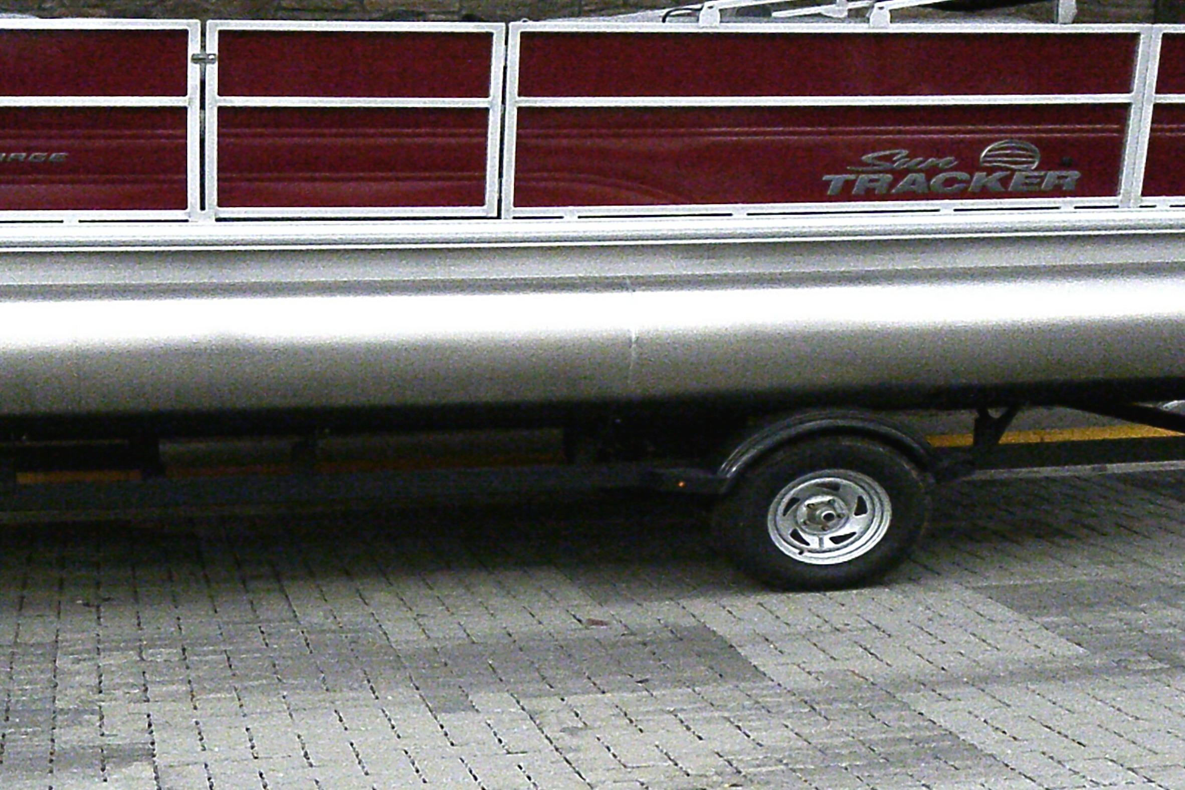 2026 Sun Tracker Party Barge 18 DLX pontoon boat on trailer, side view.