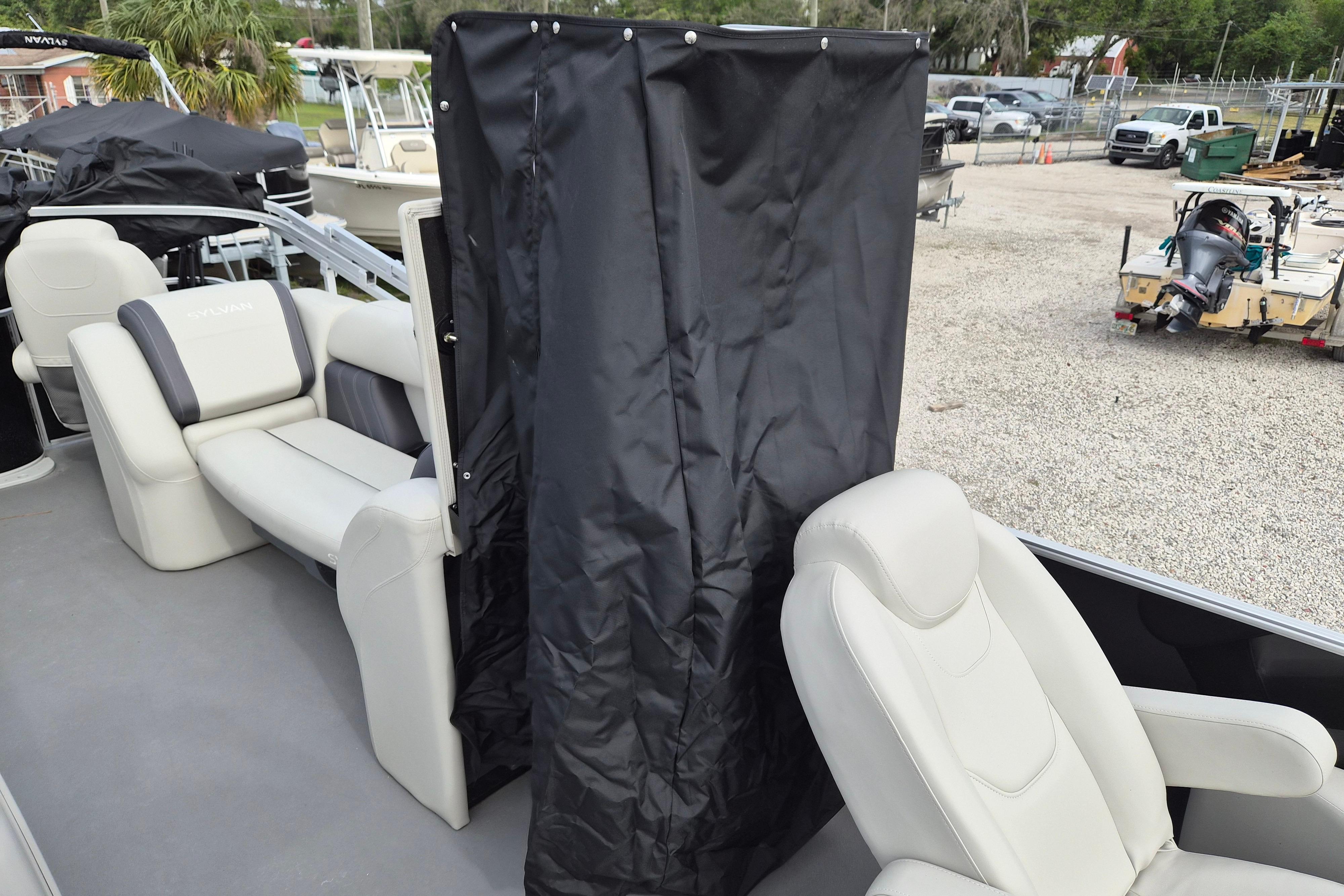 2025 Sylvan Mirage Fish 8522 Party Fish 4.0 boat interior with seating and privacy curtain.
