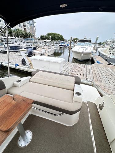 2015 Sea Ray 260 Sundancer at marina, featuring comfortable seating and wooden table.