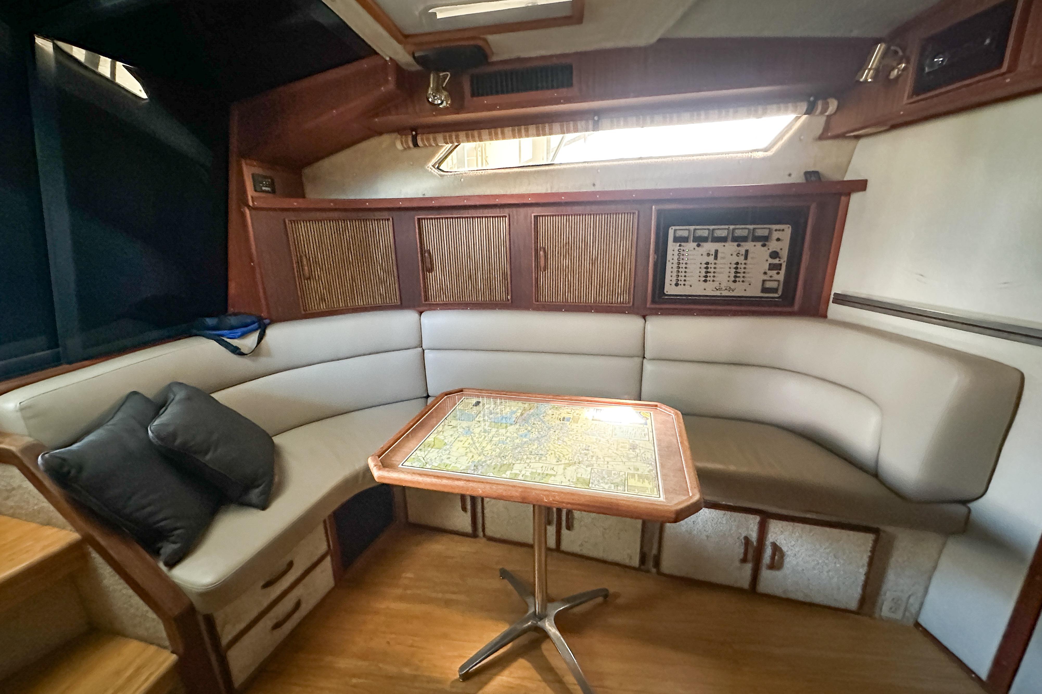 1986 Sea Ray 390 Express Cruiser interior with cozy seating and navigation table.