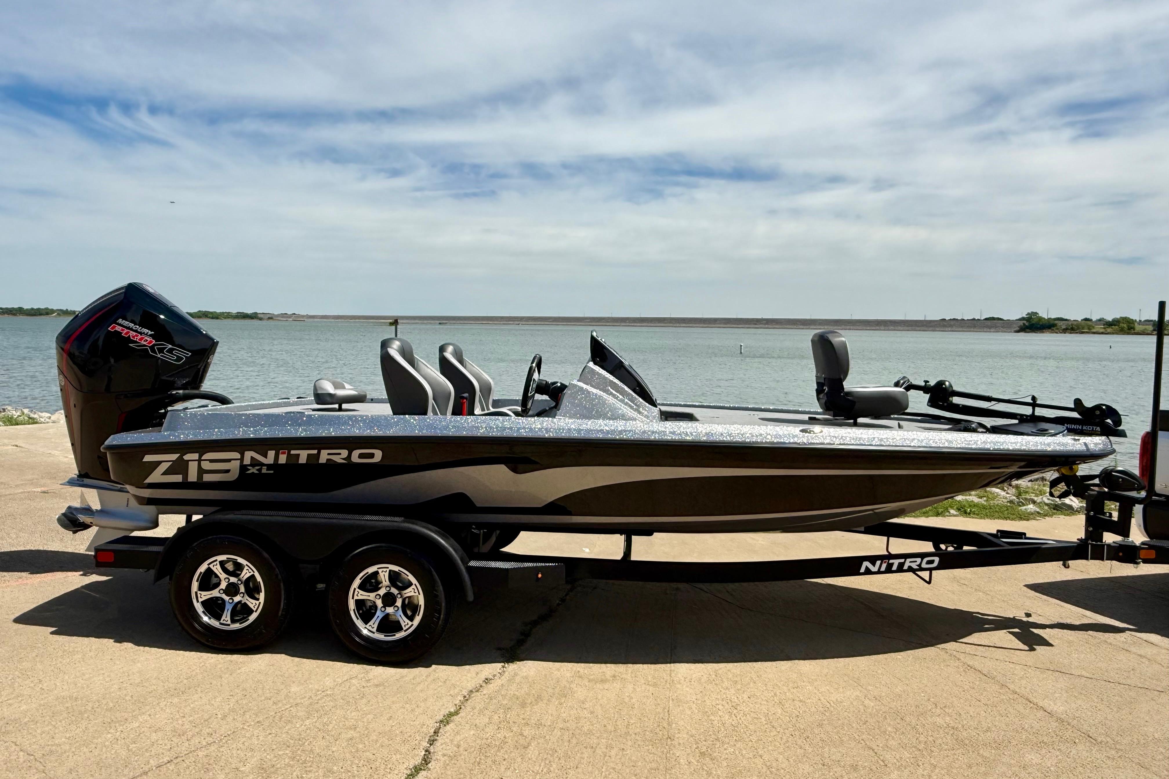 2026 Nitro Z19 XL boat on trailer by a lake, under a clear sky.