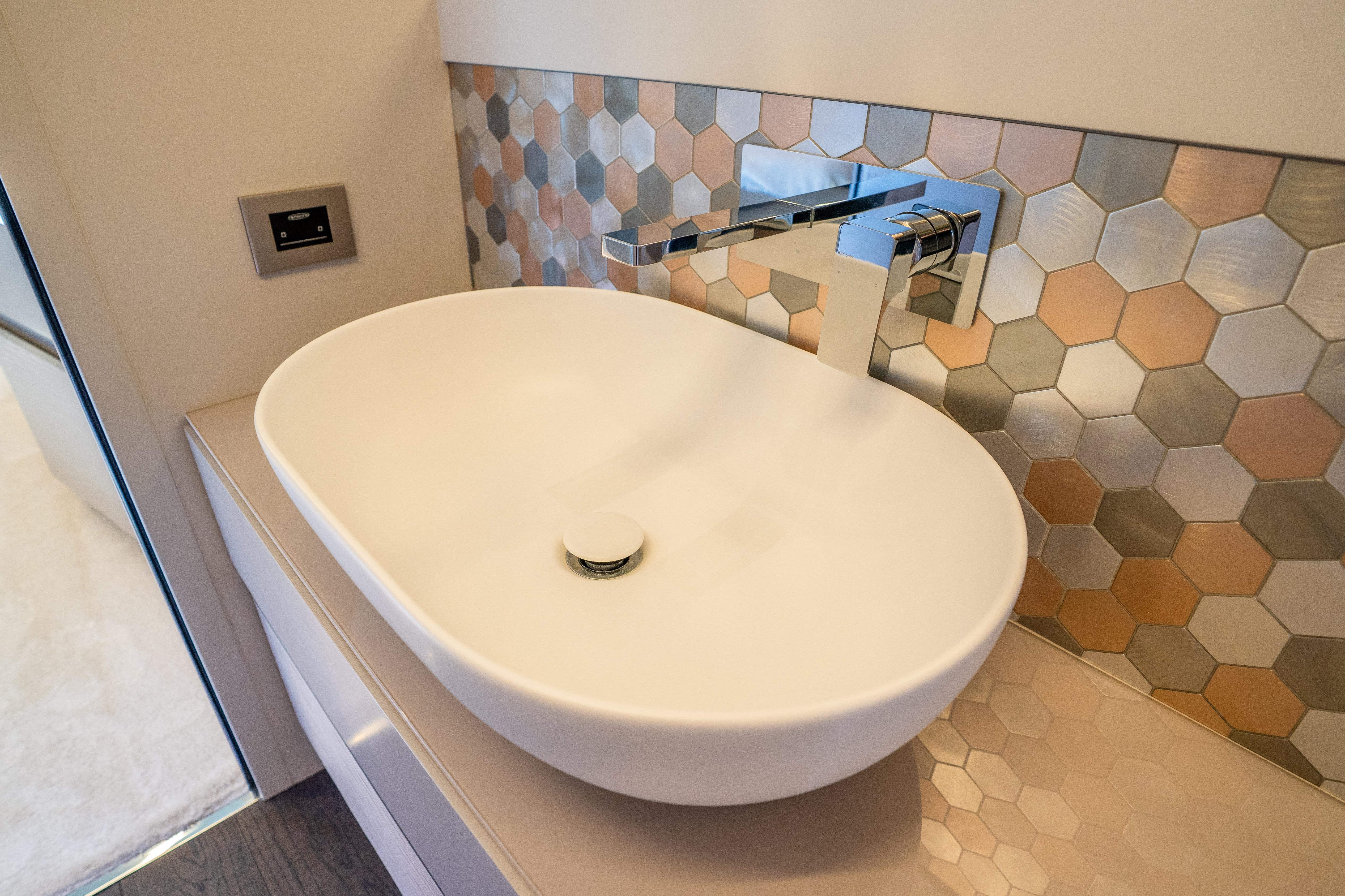 Modern bathroom sink with hexagonal tile backsplash in 2024 Pershing 7X yacht.