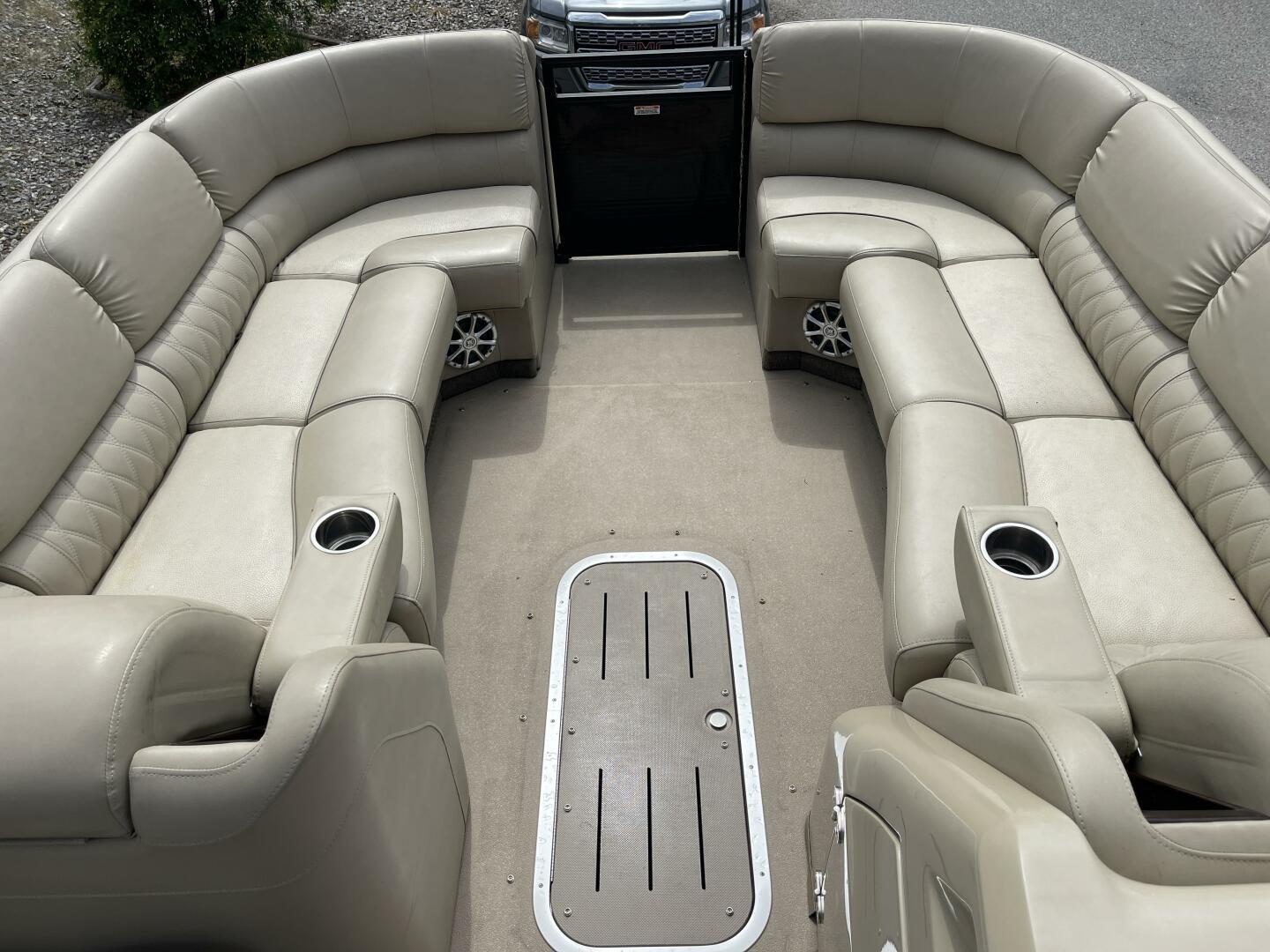 Luxurious seating on a 2013 Bennington 2575 QCW pontoon boat with beige upholstery.
