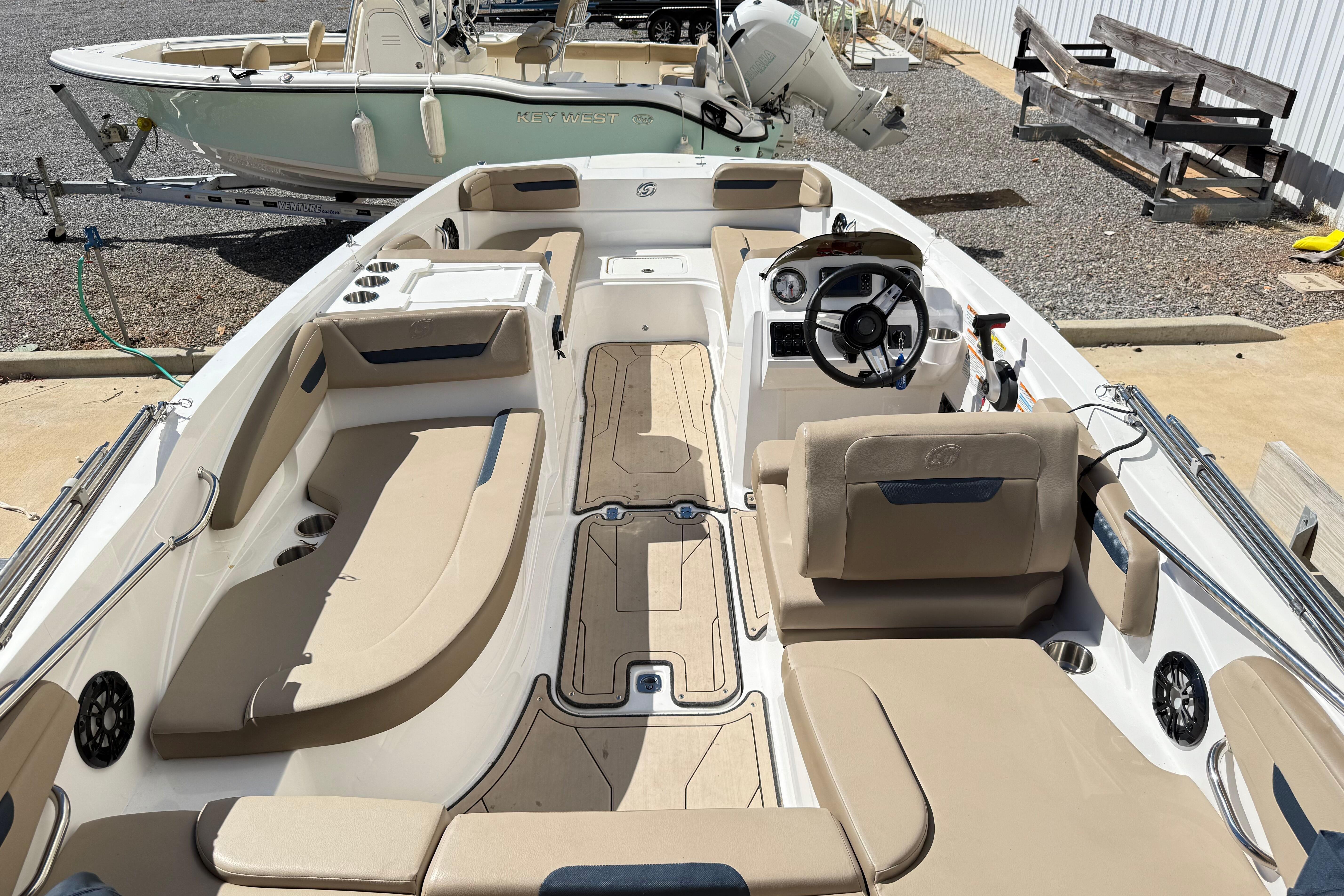 2021 Hurricane SunDeck Sport 205 IO boat with beige seating and modern dashboard.