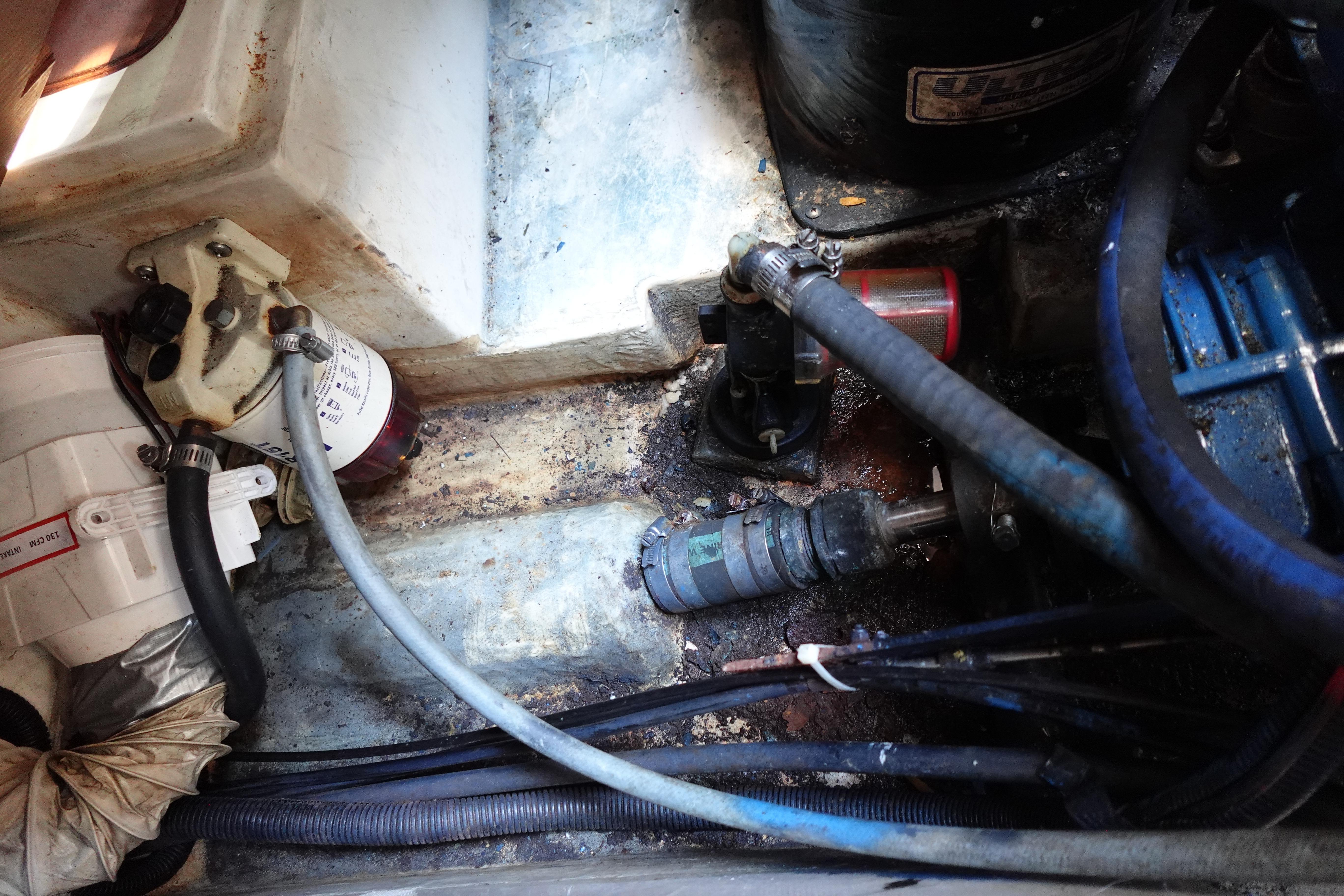 Engine compartment of a 1997 Catalina 28 sailboat, showing hoses and mechanical components.