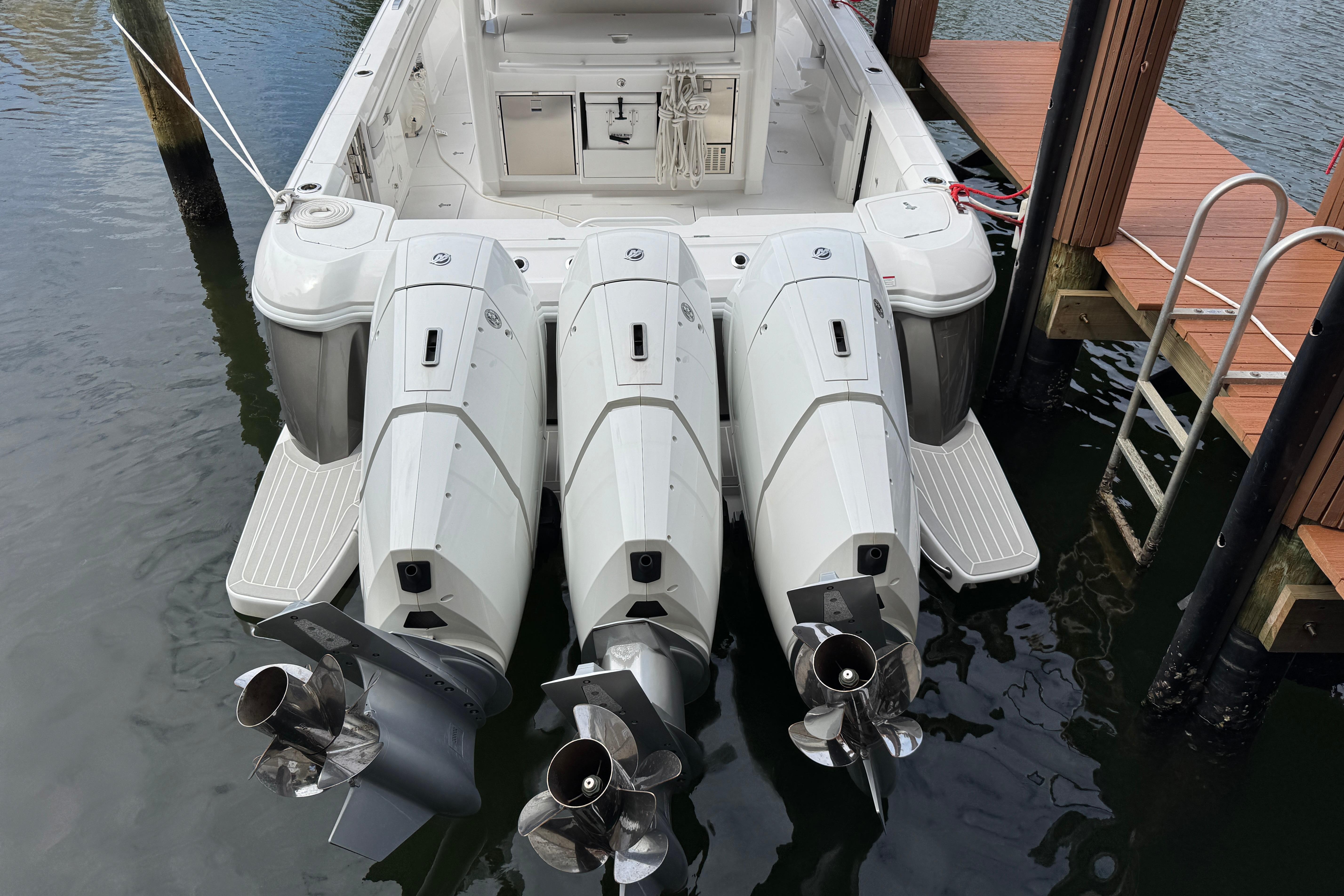 2024 Intrepid 427 Nomad SE boat with triple outboard engines docked at marina.