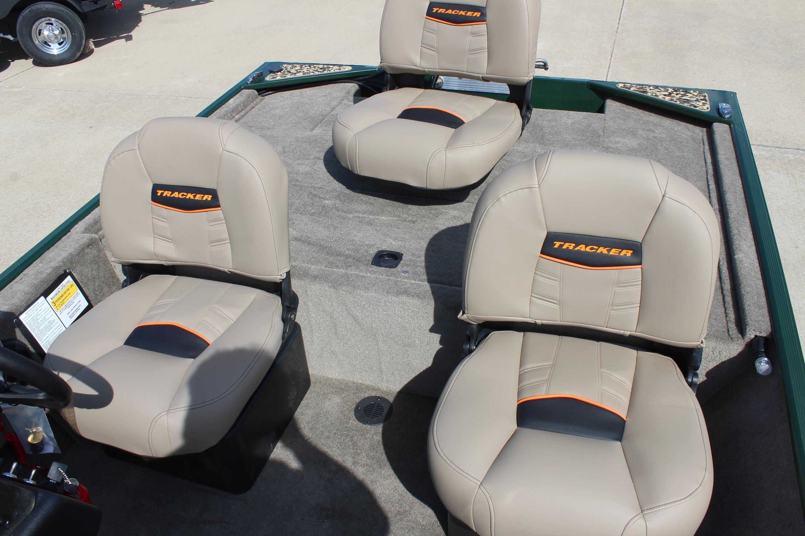 2026 Tracker Bass Tracker Classic Limited boat seats, beige with orange accents, on a carpeted deck.