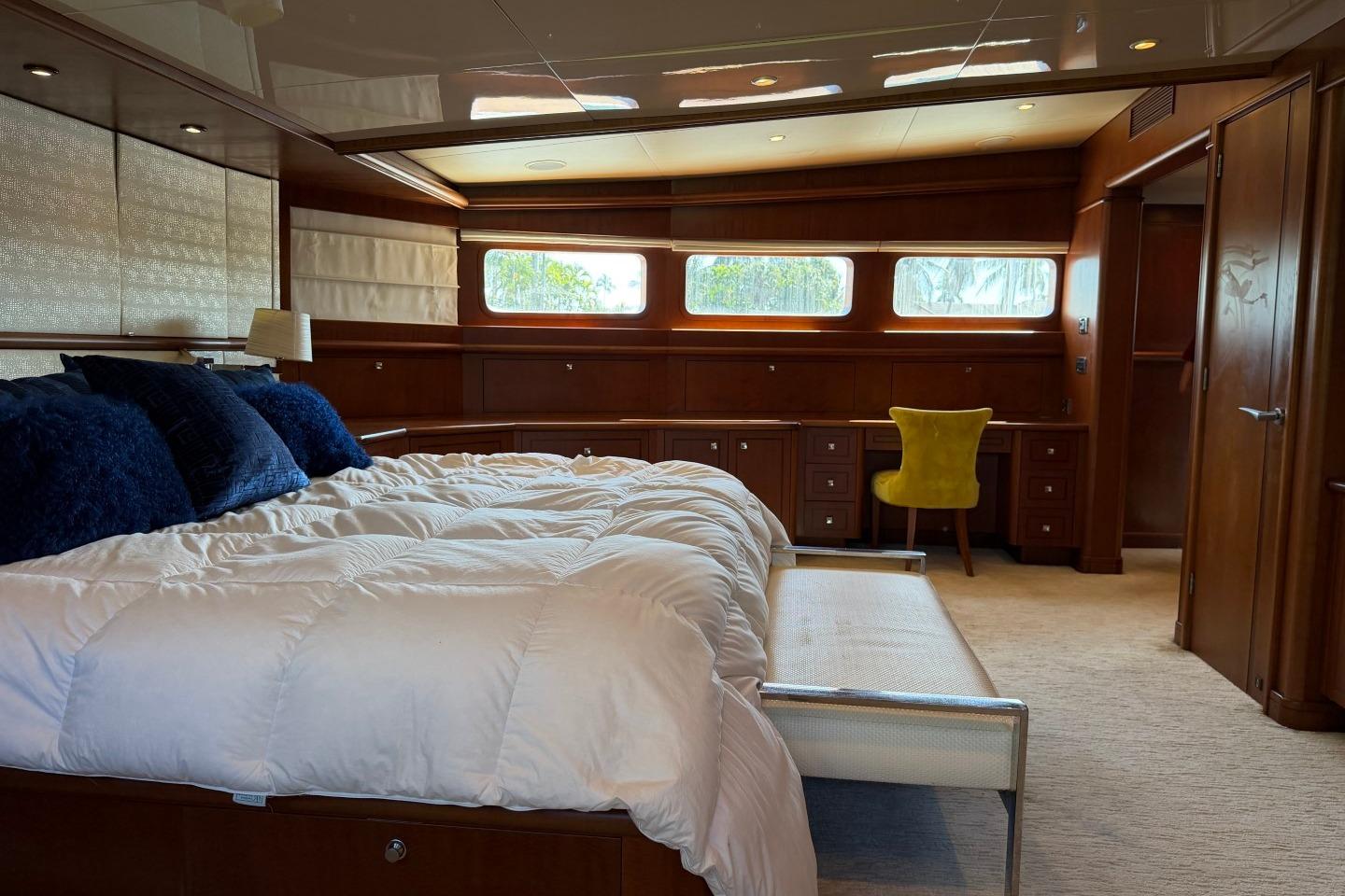 Luxurious bedroom interior on 1990 Heesen 144 yacht with elegant wood paneling and plush bedding.