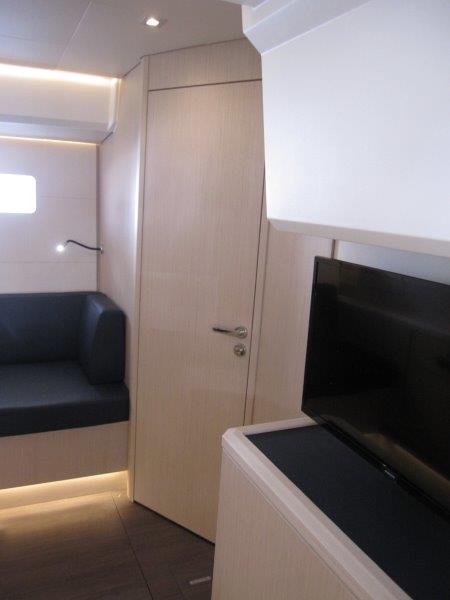 Interior of 2024 Jeanneau 60 yacht with modern seating and TV.