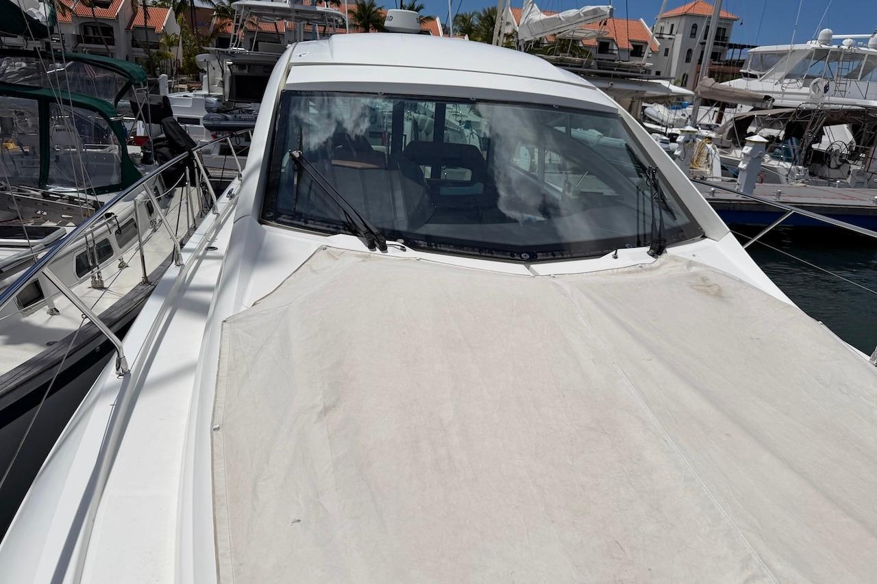 2018 Beneteau Gran Turismo 46 yacht docked at marina, covered deck, sunny day.