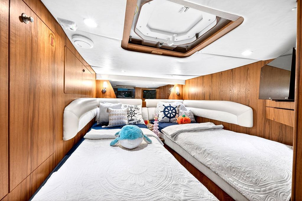 Luxurious 2006 Tiara Yachts 4300 Sovran cabin with twin beds and nautical decor.