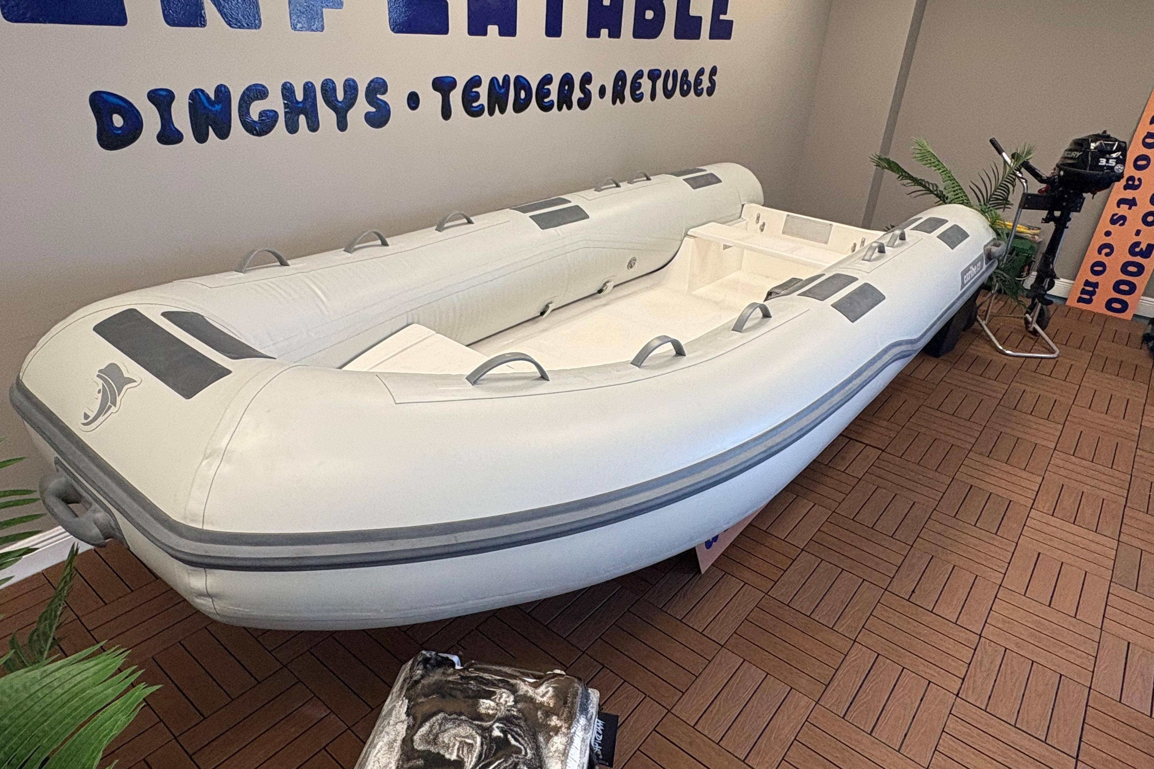 Inflatable Caribe C-13 dinghy, 2026 model, displayed indoors on wooden flooring.