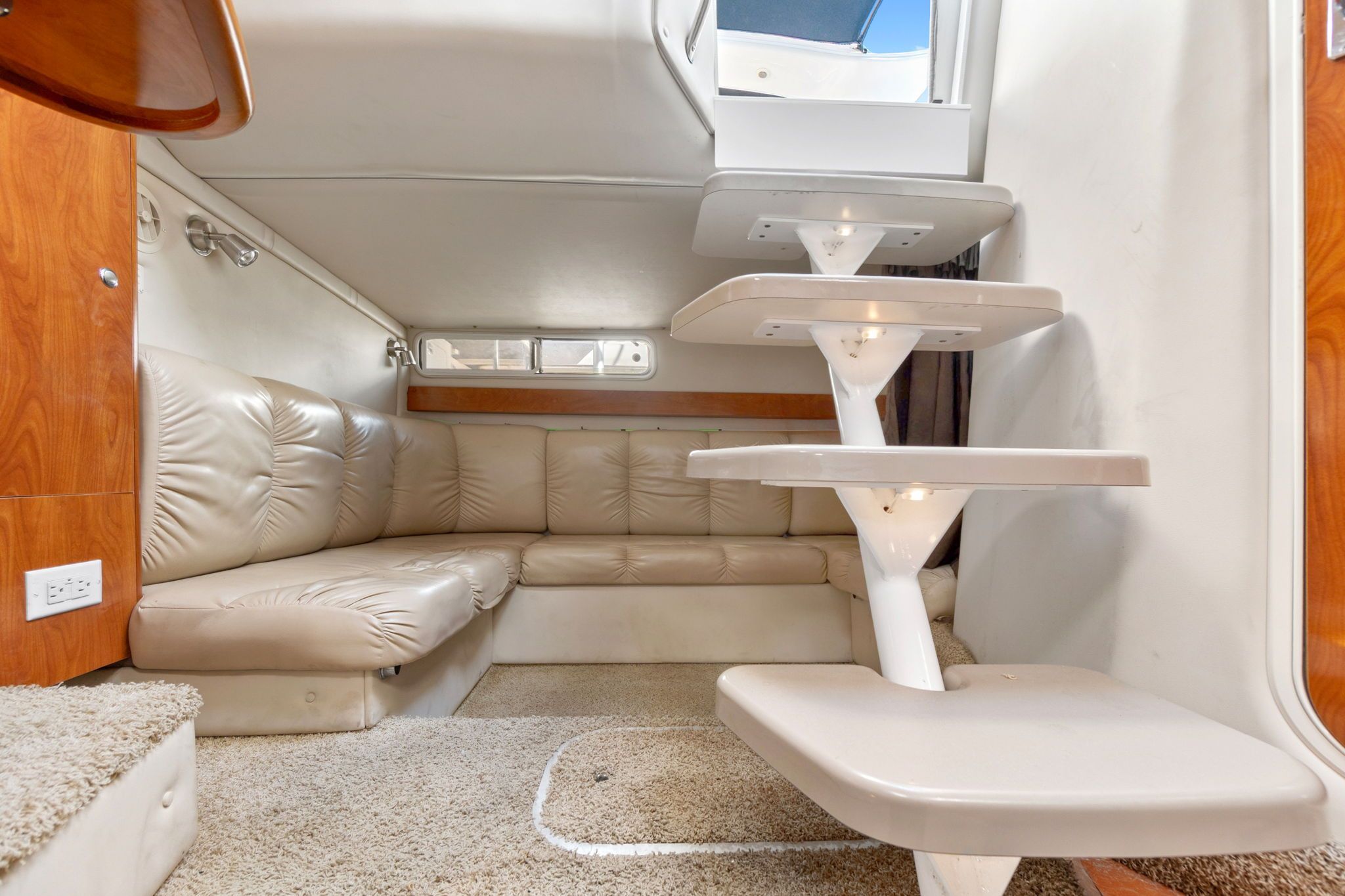 Interior of the 2007 Larson Cabrio 330 with beige sofa and staircase.