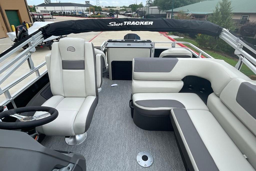 2026 Sun Tracker Fishin' Barge 22 XP3 interior with plush seating and steering console.