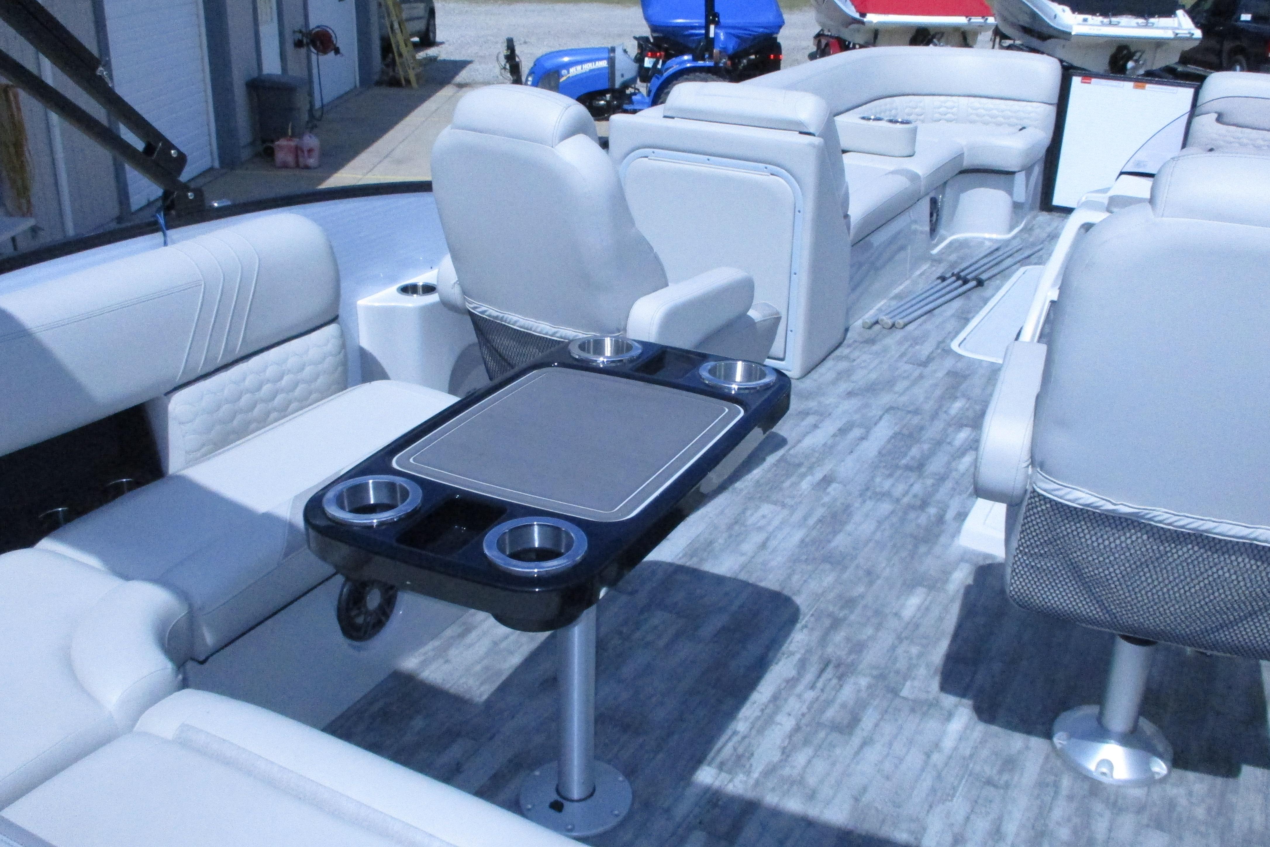Luxurious interior of 2021 Crest Caribbean LX 250 SLS pontoon boat with seating and table.