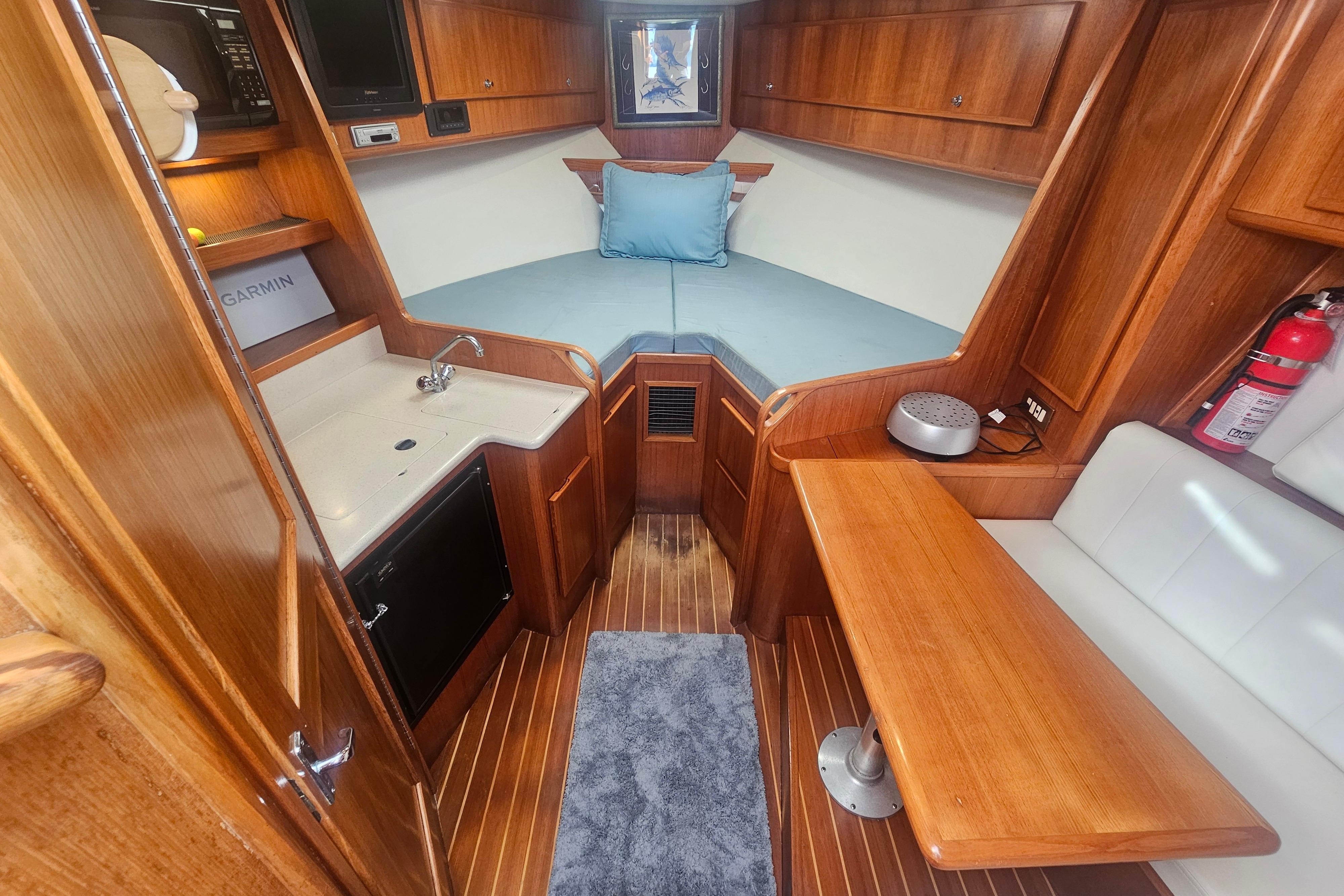 Interior of 2003 Topaz 32 Express boat with wood finish and compact amenities.