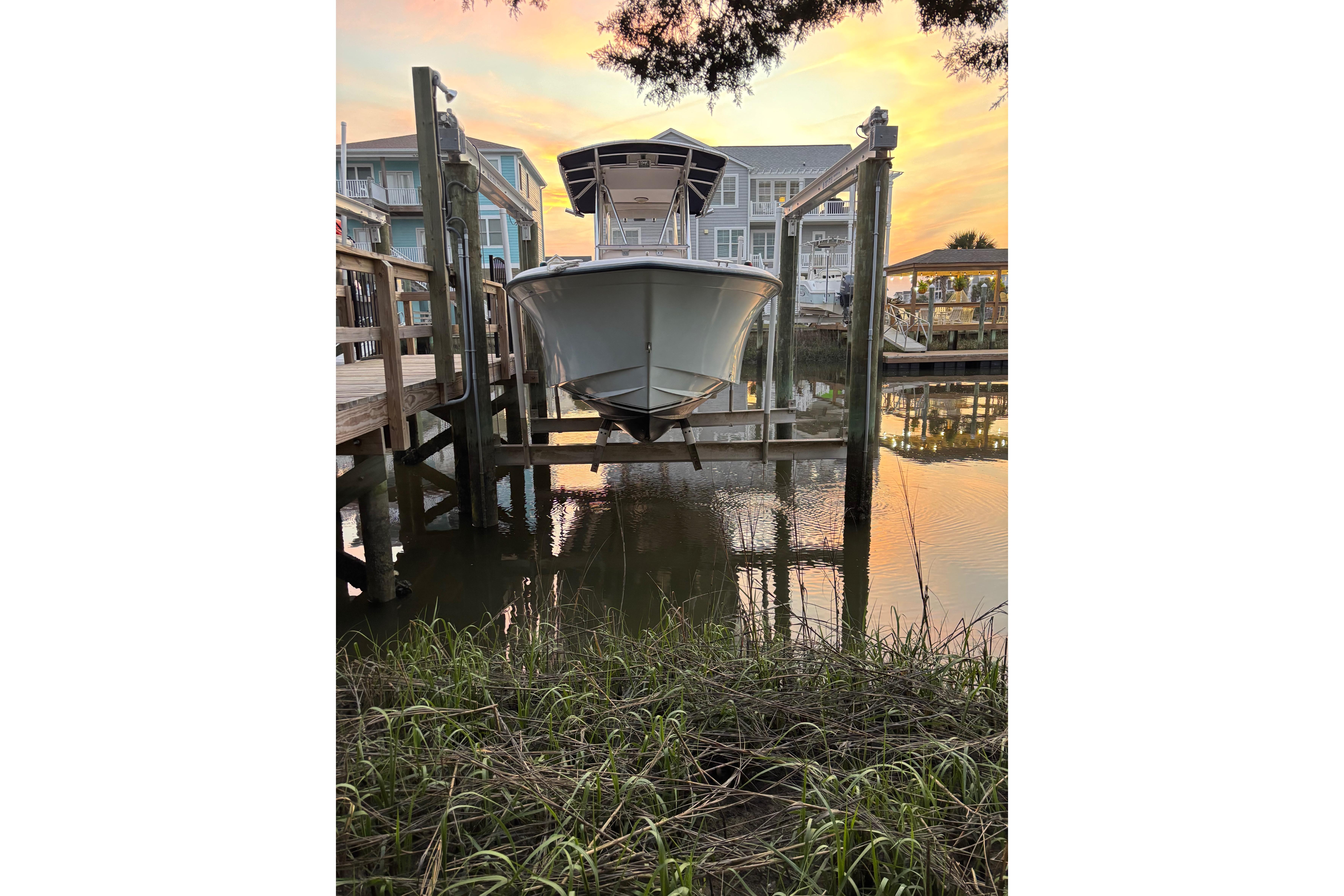 2006 Grady-White Advance 257 boat docked at sunset, reflecting on calm water.
