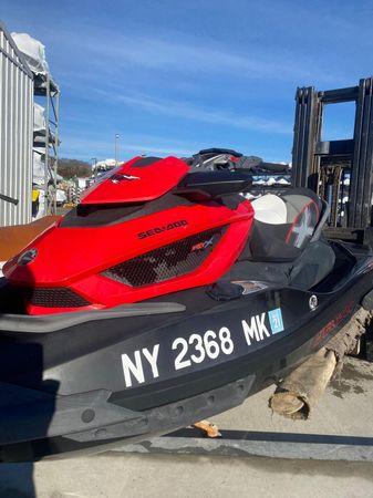 2014 Sea-Doo RXT-X aS 260 jet ski, red and black, parked outdoors.