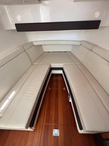 2019 Pursuit S 408 Sport boat interior with beige seating and wooden flooring.