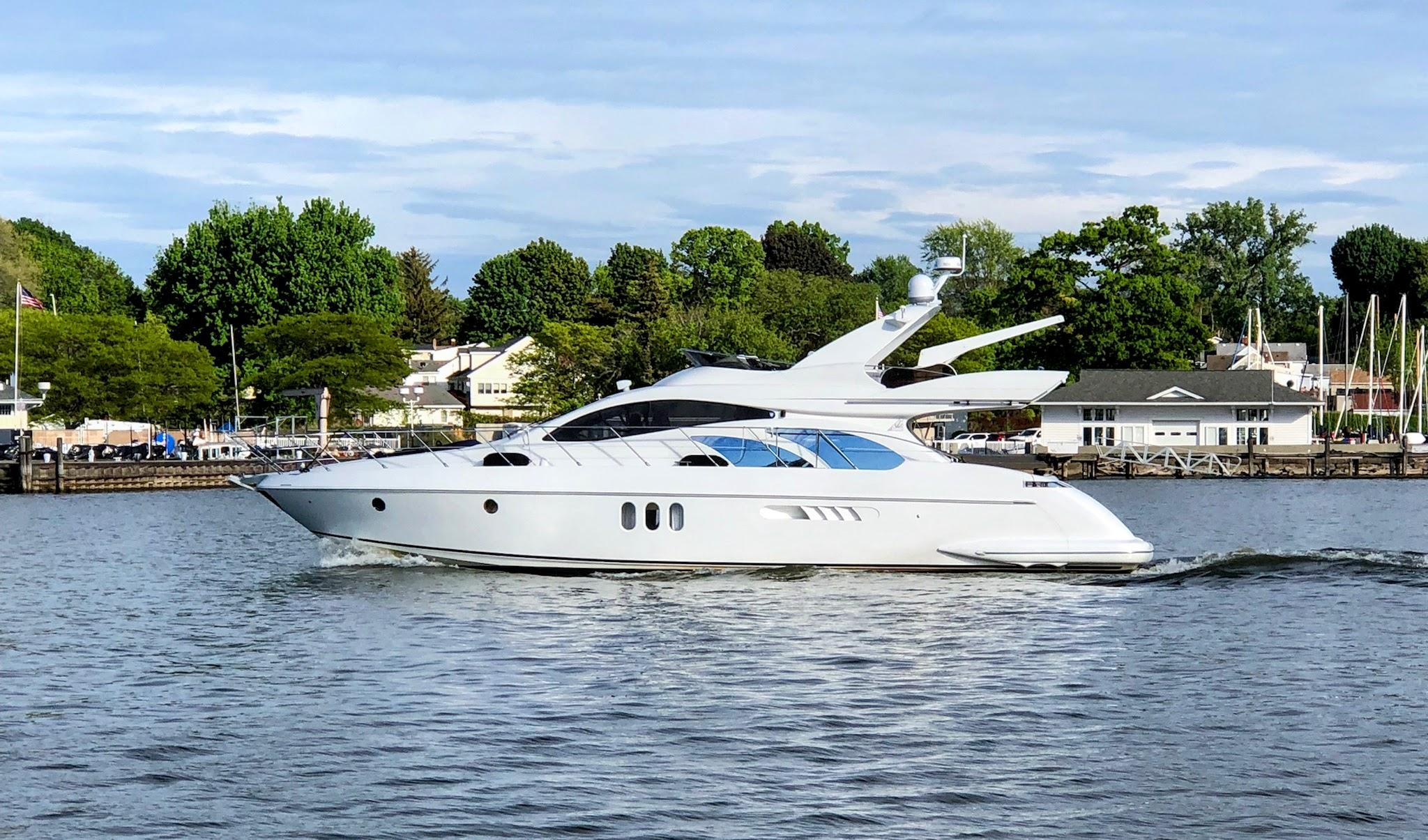 2002 Azimut 55 yacht cruising on a calm river near a marina.