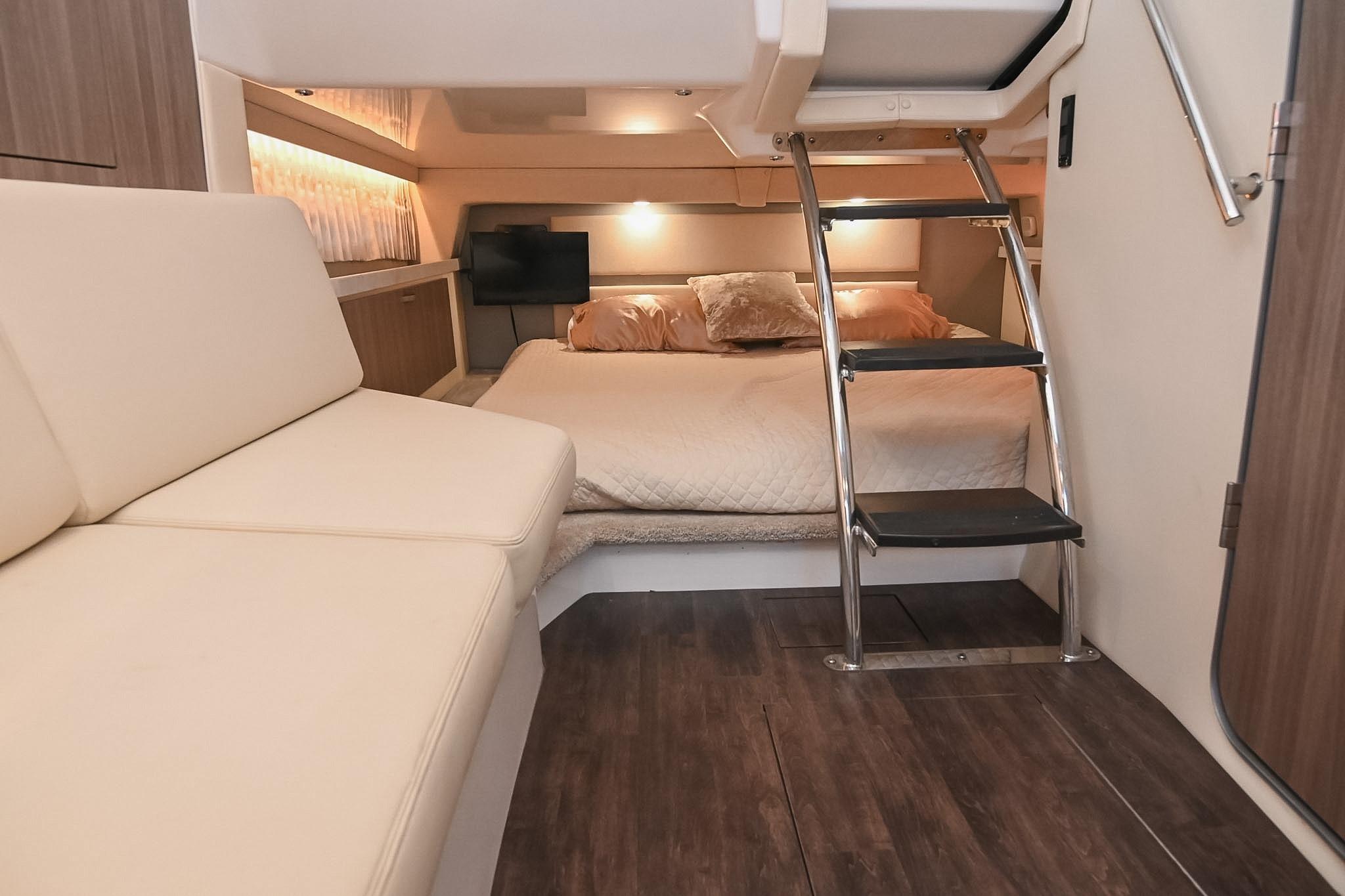 Luxurious interior of 2021 Regal 33 Express yacht with cozy bed and modern decor.