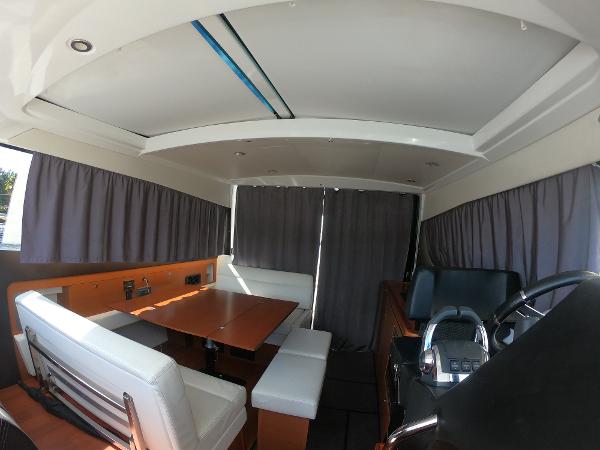Interior of 2017 Jeanneau NC 11 boat with dining area and helm station.