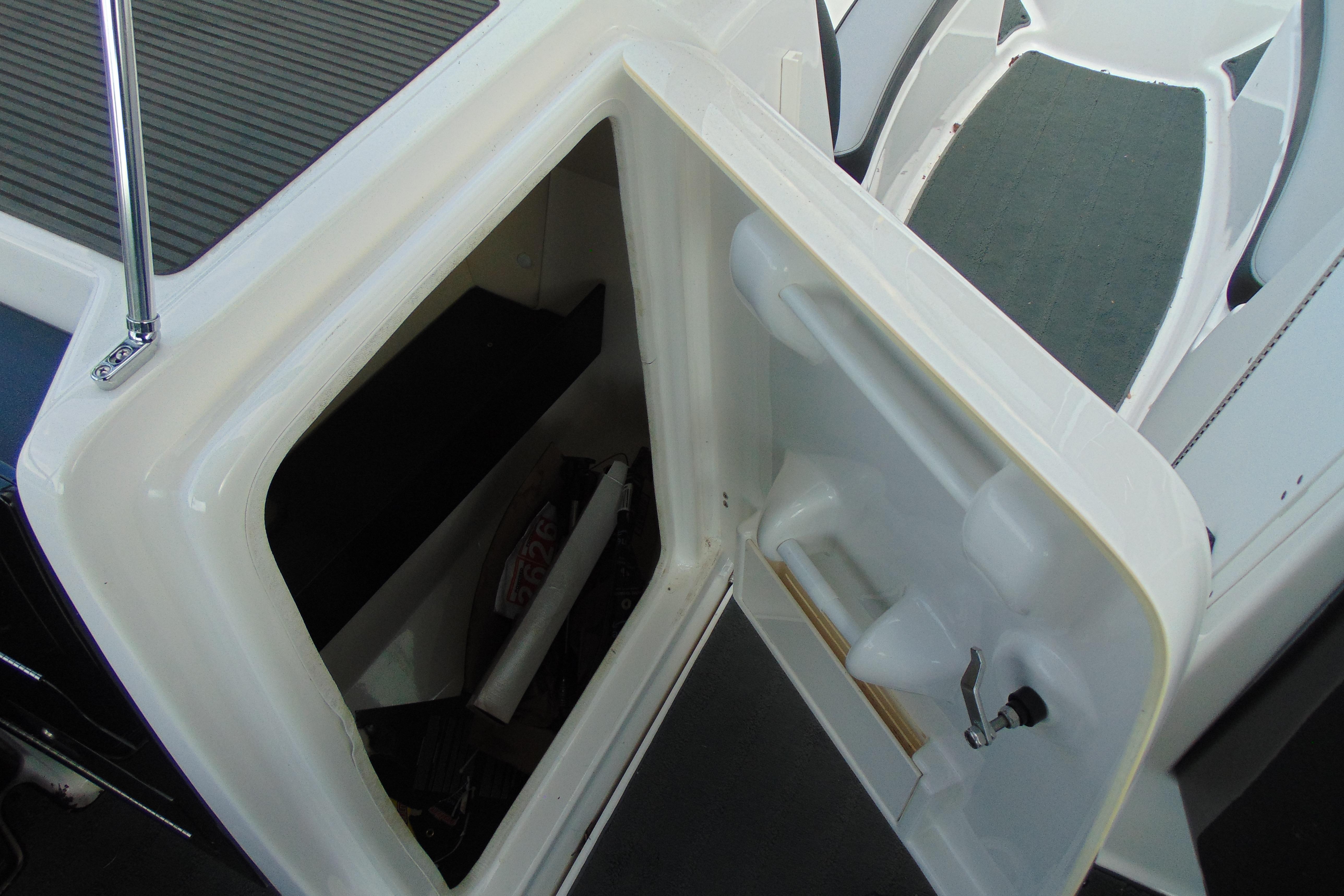2016 Yamaha Boats 242X E-Series storage compartment with open door, showcasing interior space.