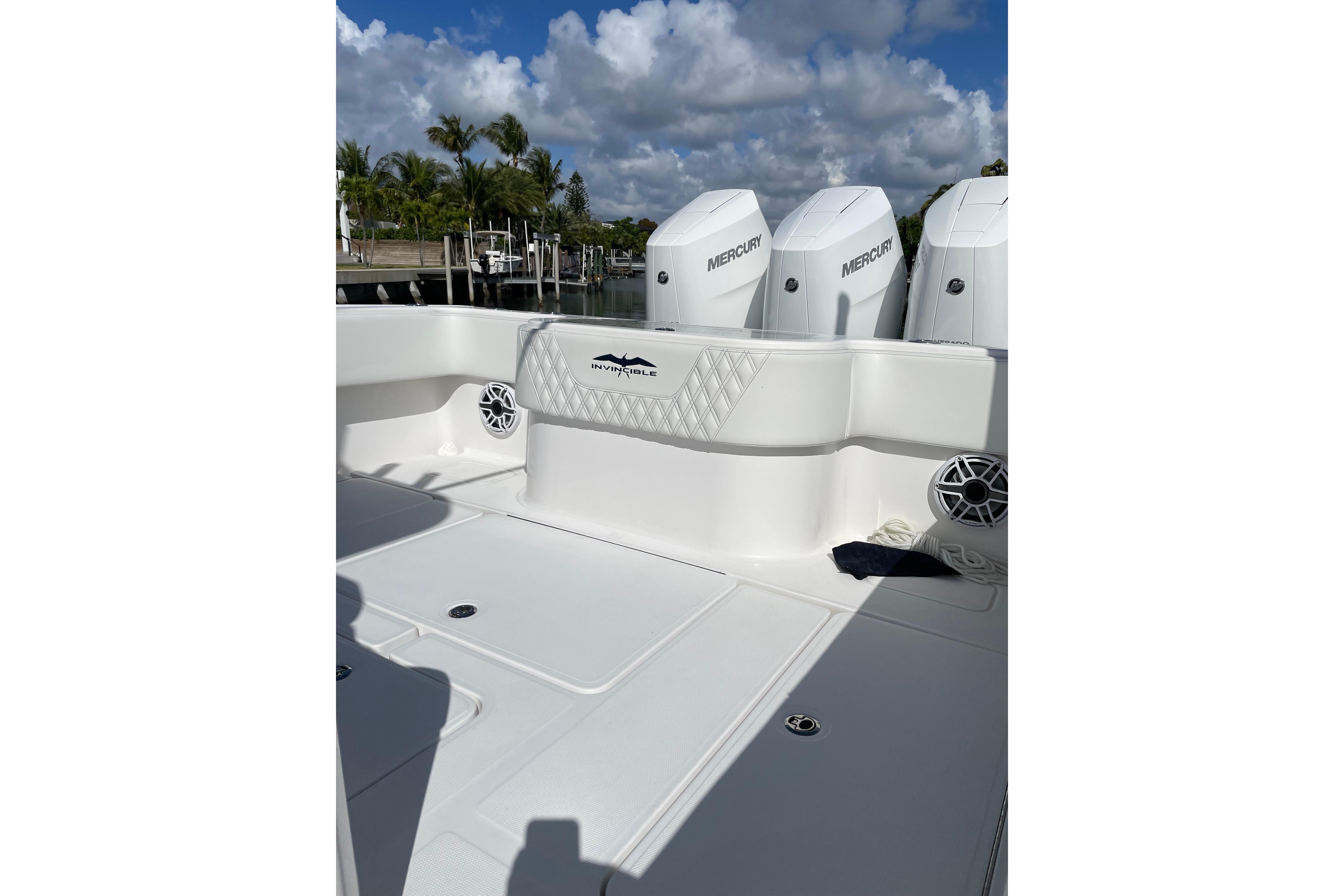 2024 Invincible 36 Open Fisherman boat with Mercury engines, docked under a cloudy sky.