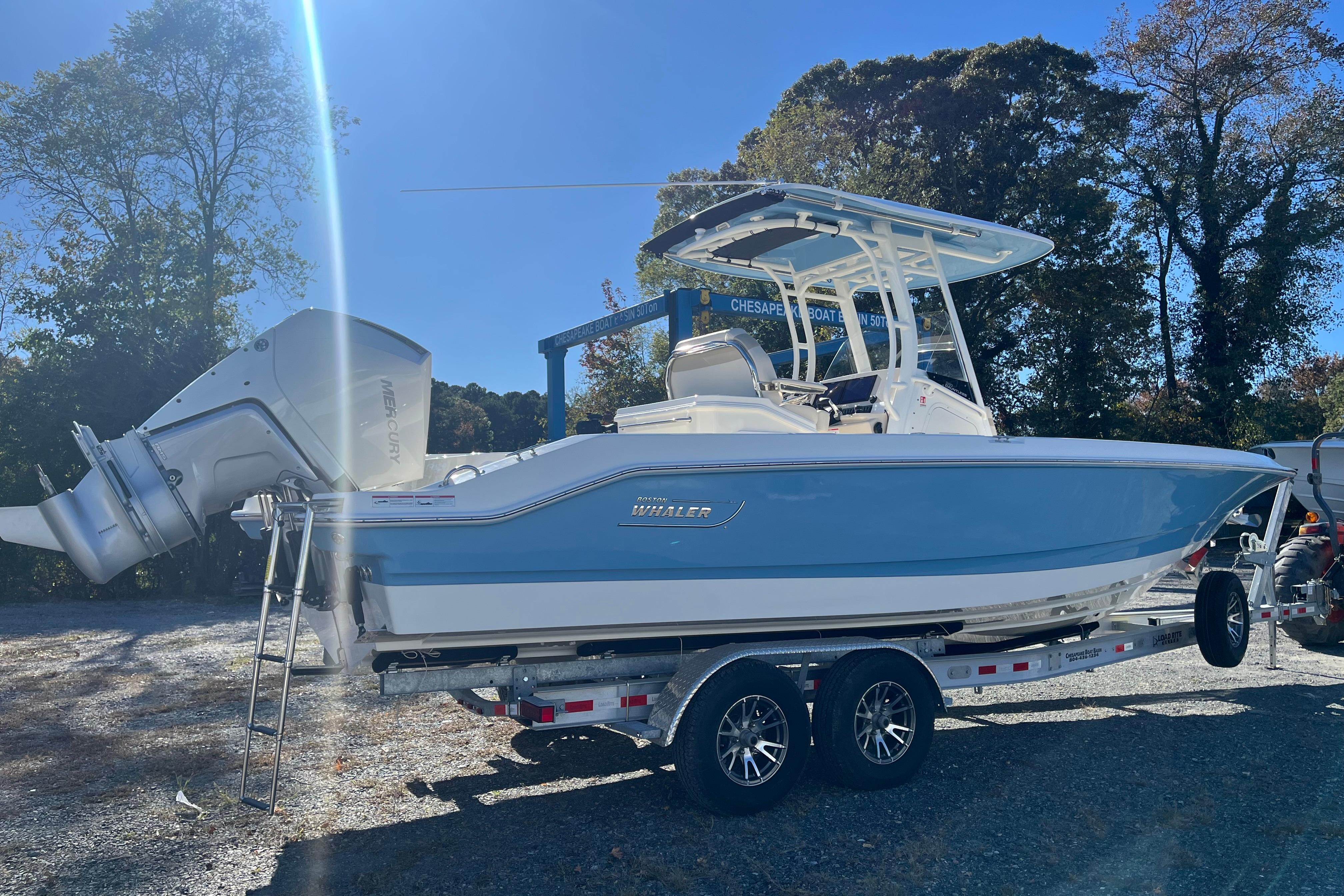 2026 Boston Whaler 280 Dauntless boat on trailer, parked outdoors under clear blue sky.