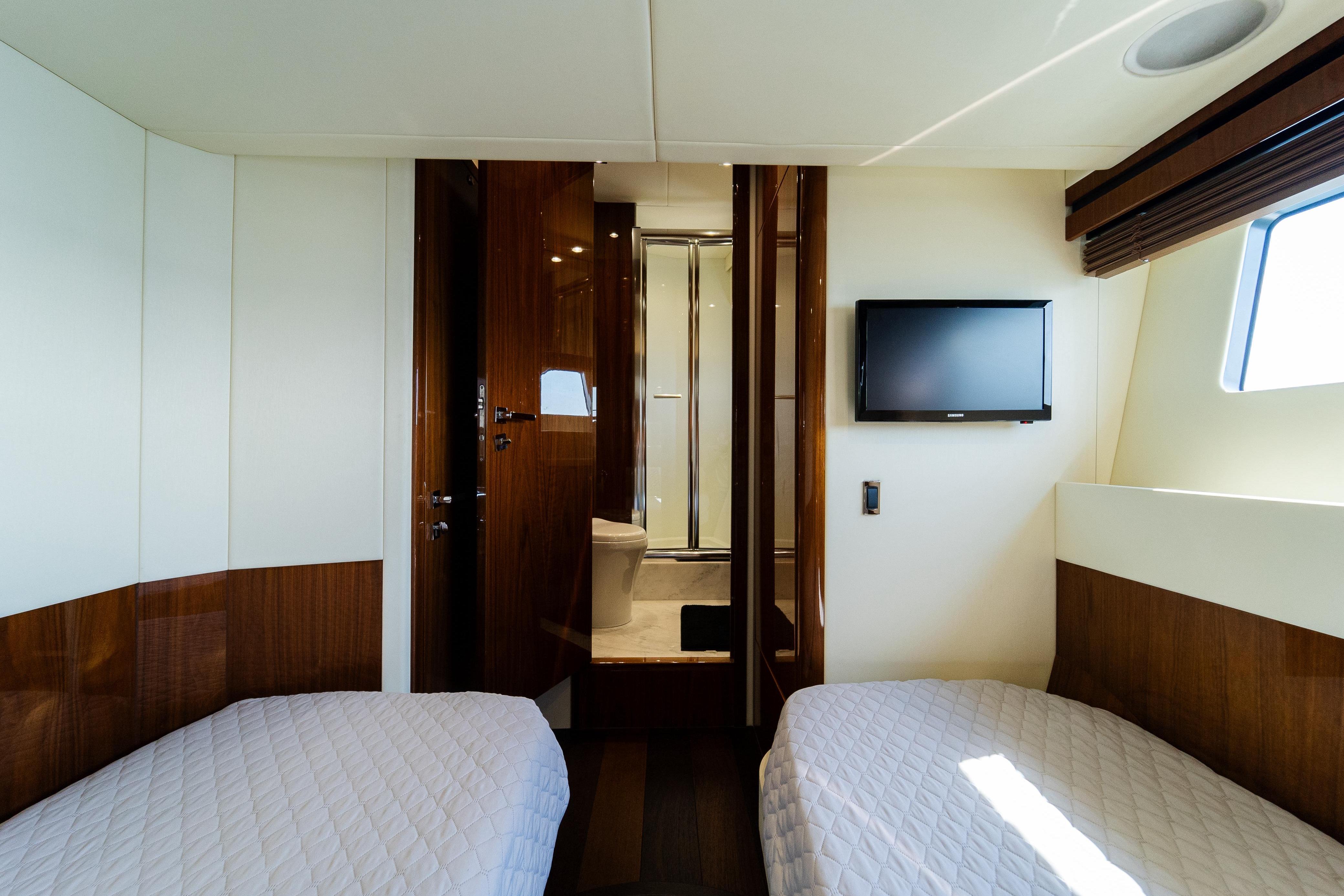 Luxurious cabin interior of 2016 Sunseeker Manhattan 65 yacht with twin beds and TV.