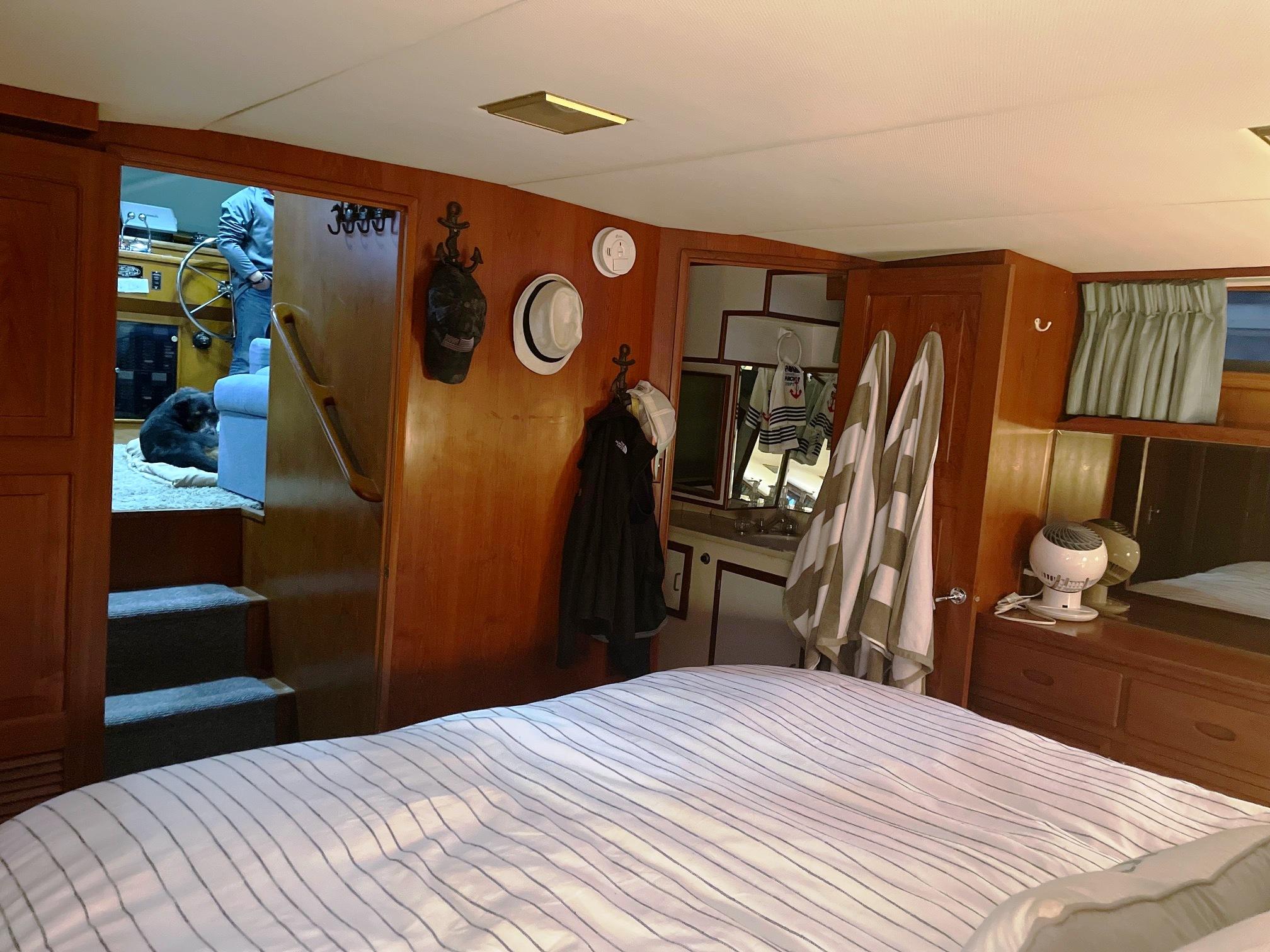 Cozy interior of 1989 Marine Trader 47 CMY yacht with wood paneling and striped bedding.