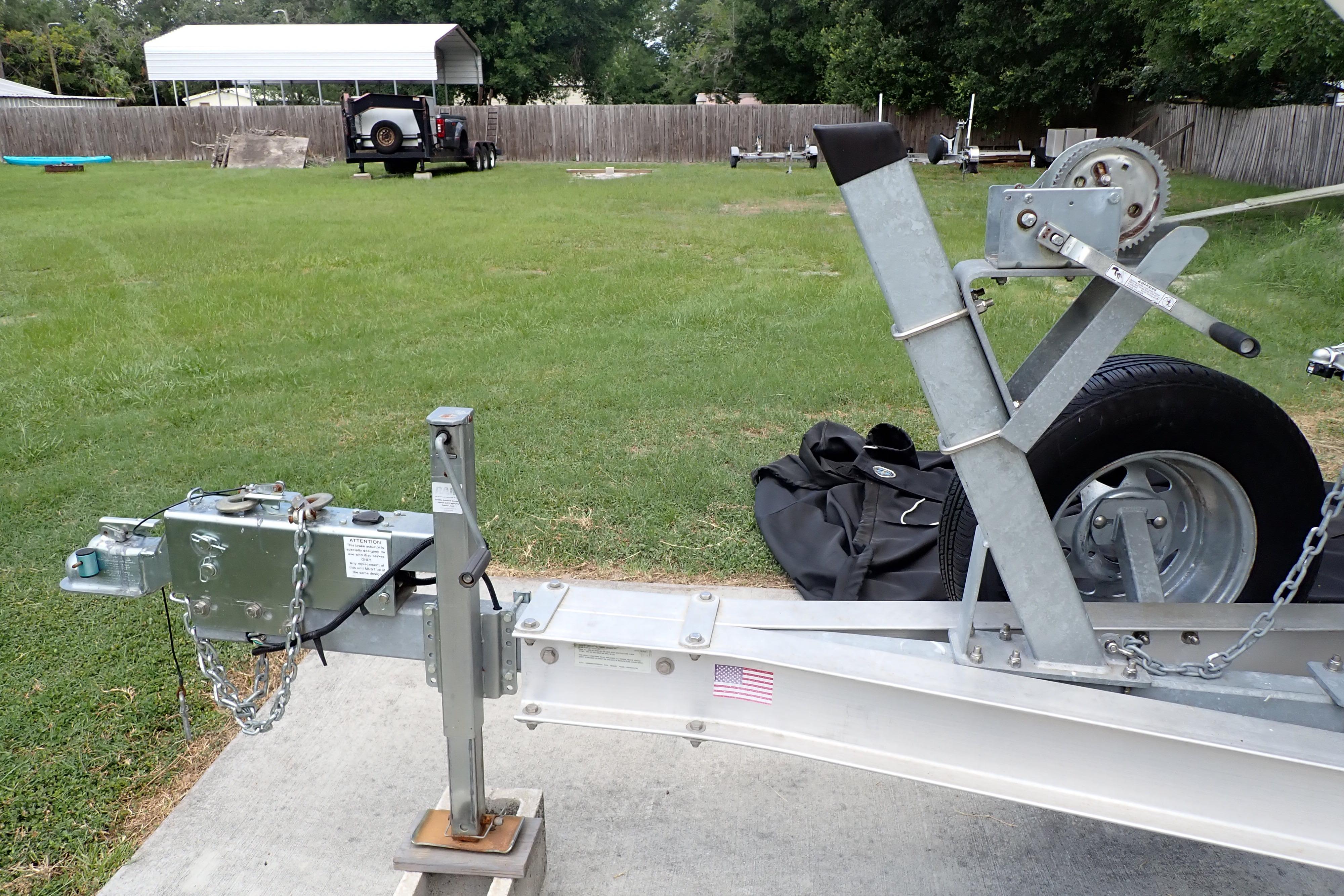 Trailer hitch and winch system for 2019 Key West 263 FS boat on grassy area.