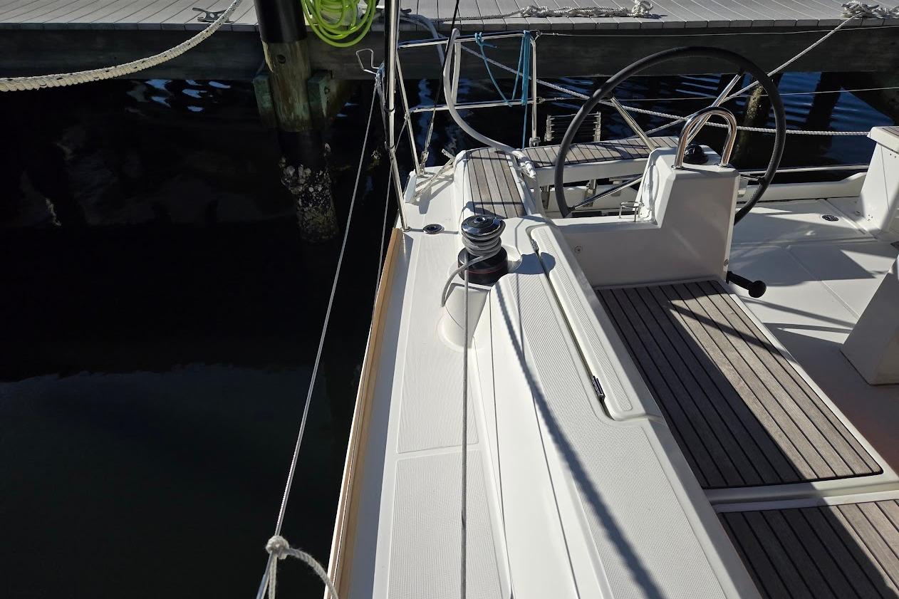 2023 Beneteau Oceanis 38.1 sailboat deck with steering wheel and winch.