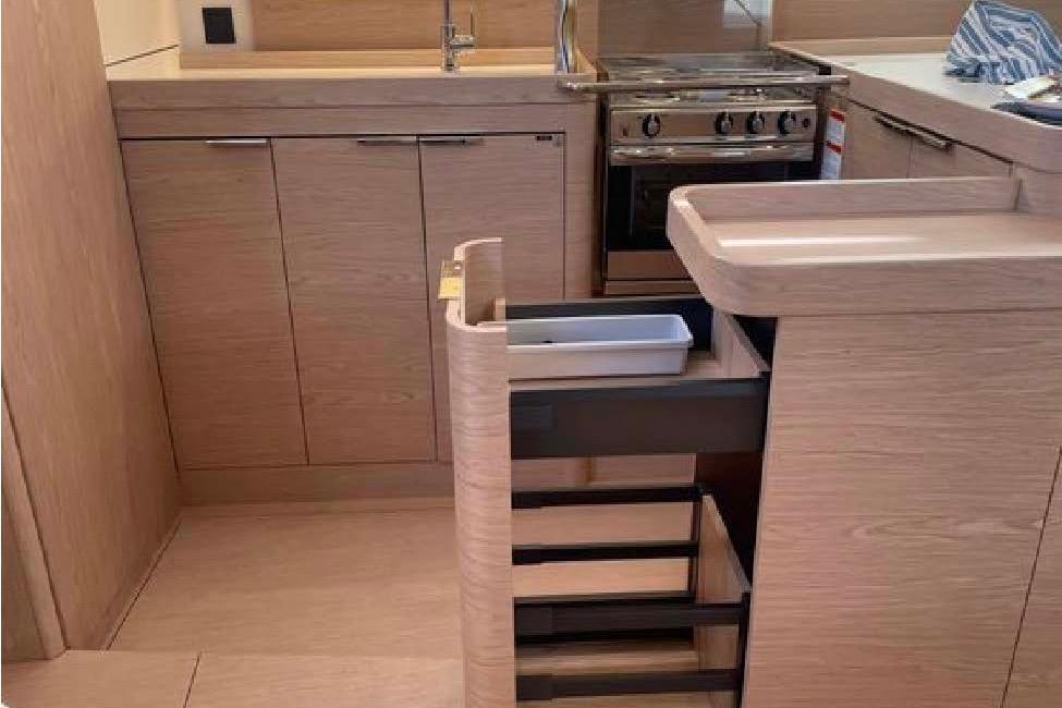Modern kitchen interior of 2022 Beneteau Oceanis Yacht 54 with sleek cabinetry and appliances.